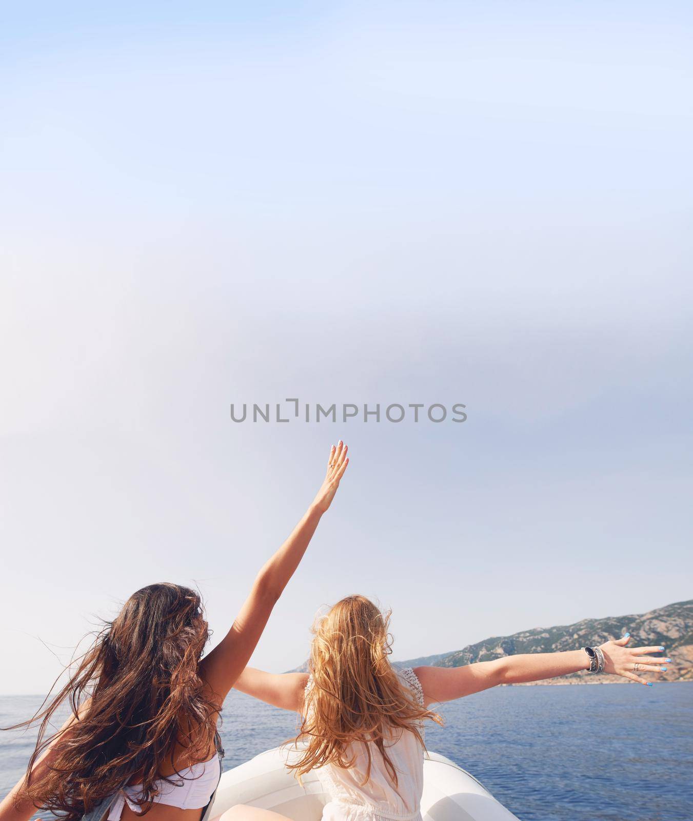 Beautiful girl friends arms raised travel on speed boat to paradise island for relaxing nature tourist destination vacation discover explore by YuriArcurs