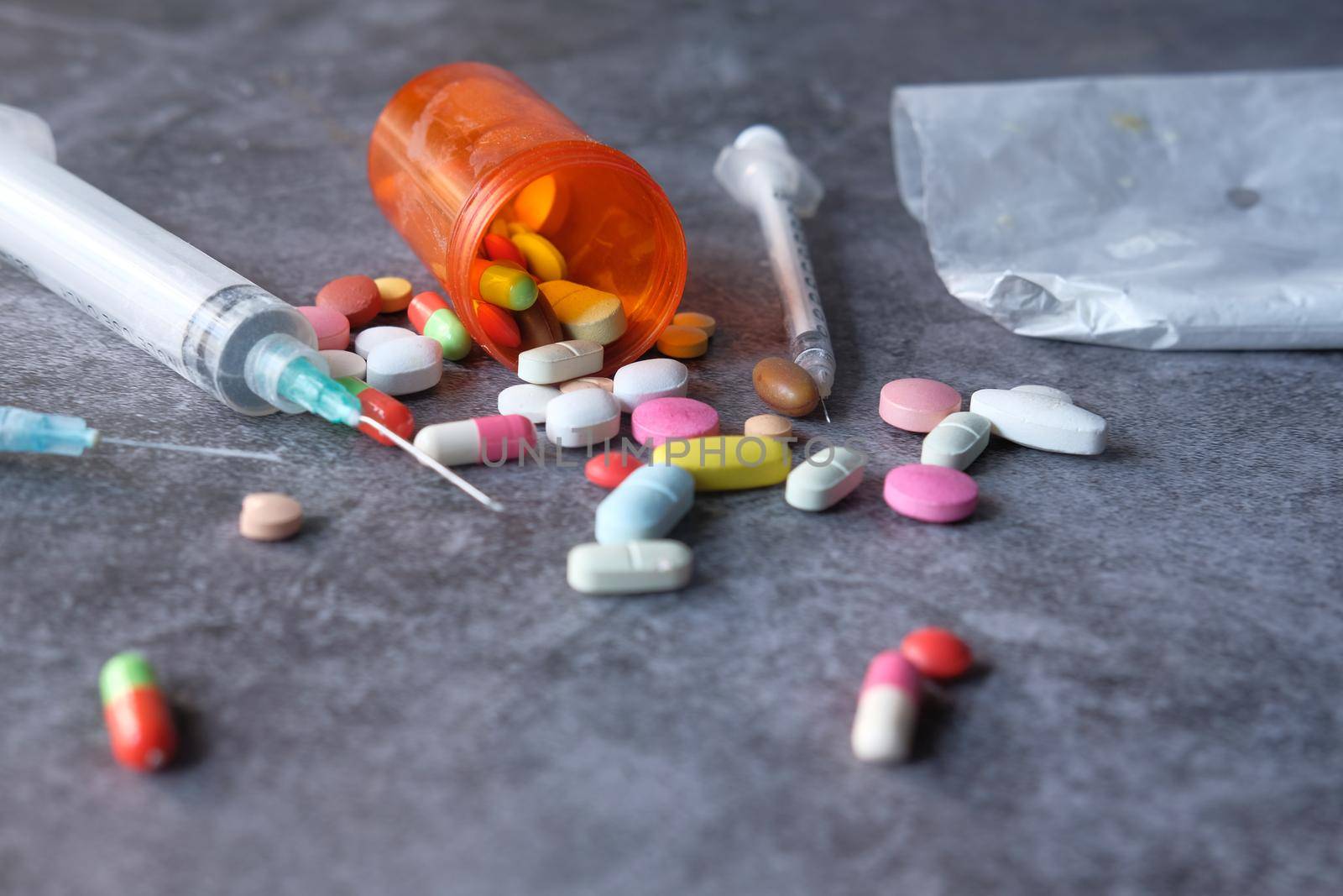 drug addiction concept with heroine packet and syringe on black backgrund .