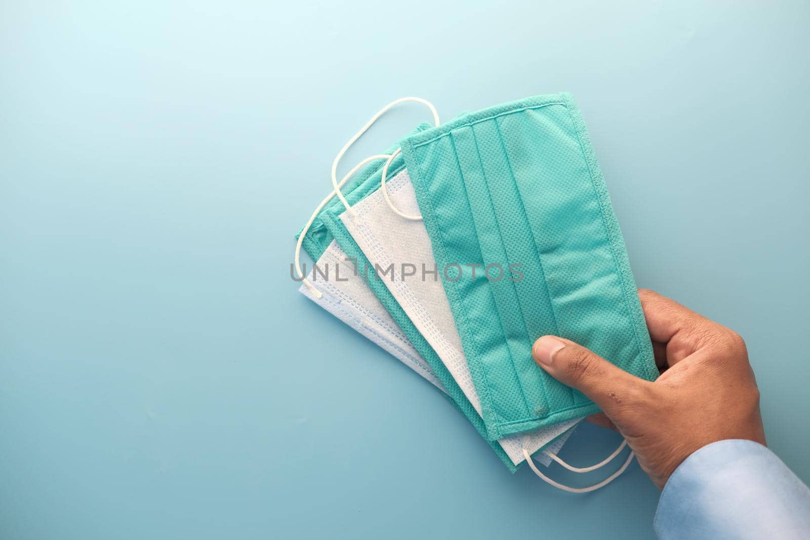 man hand holding surgical face mask, close up .
