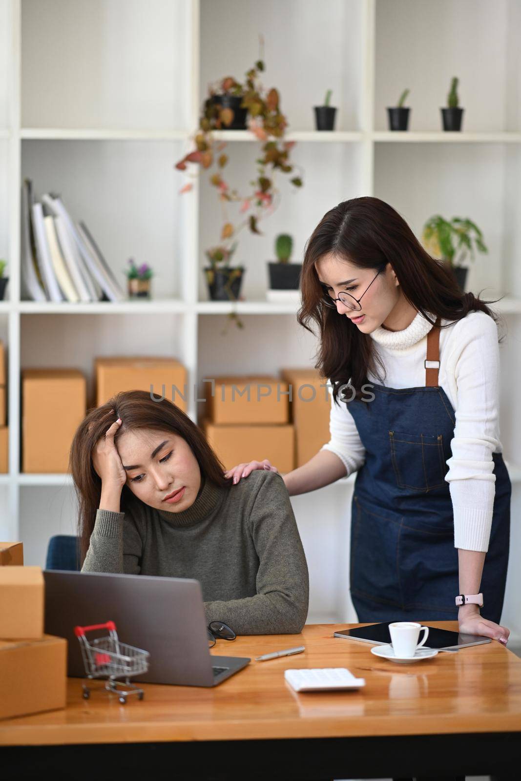 Caring asian woman comforting her upset friend having problems in business. by prathanchorruangsak
