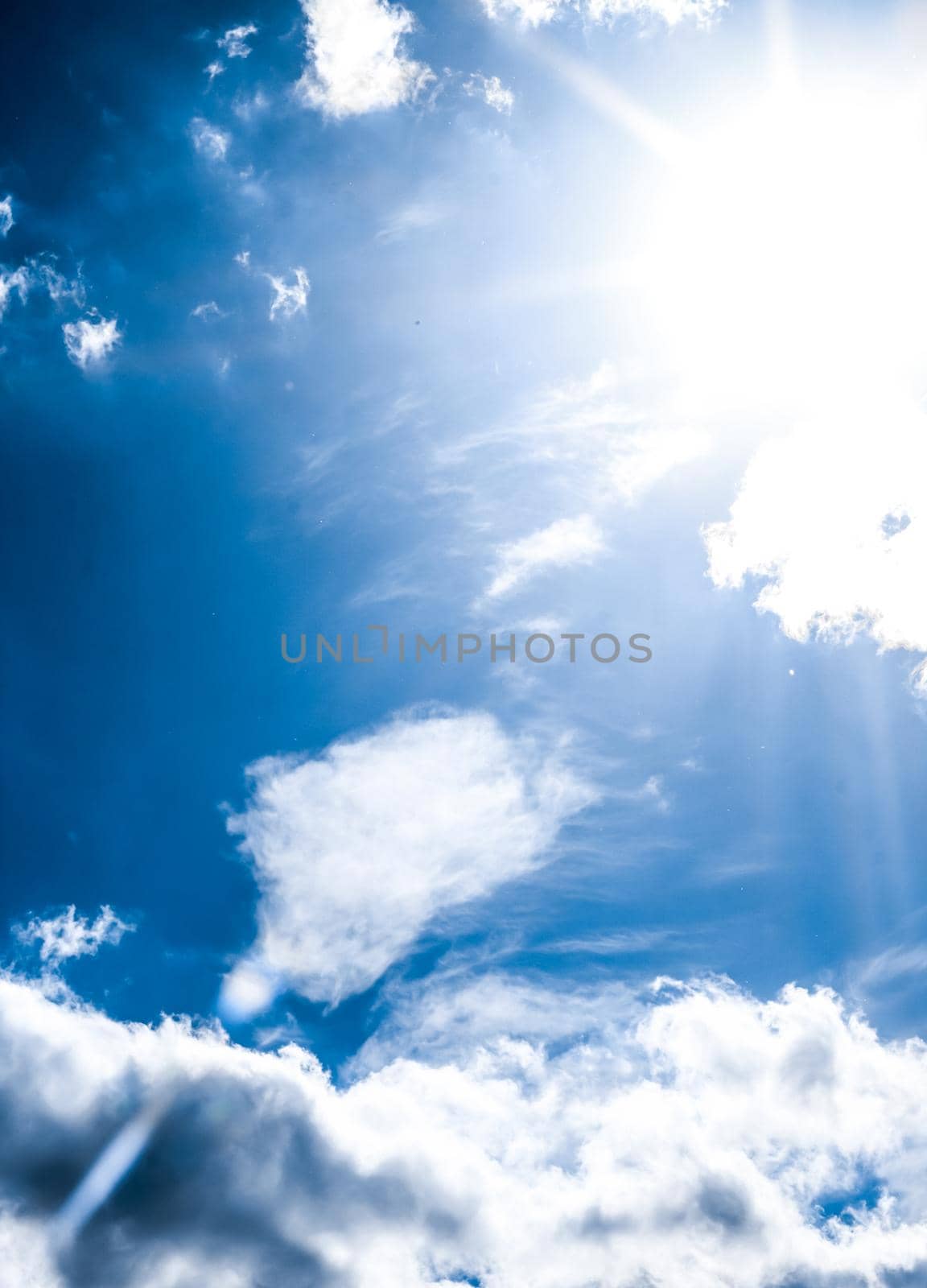 Nature backdrop, solar energy and spiritual concept - Blue sky background, white clouds and bright sunlight