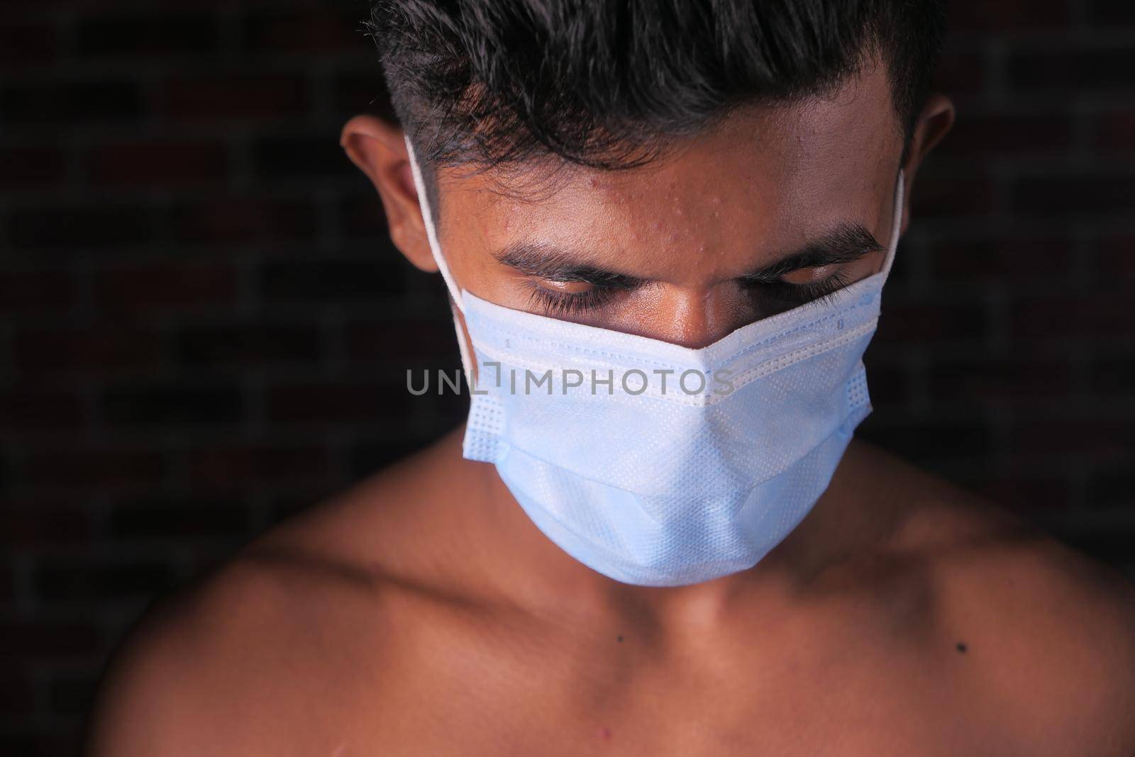 young man with protective face mask isolated on black .