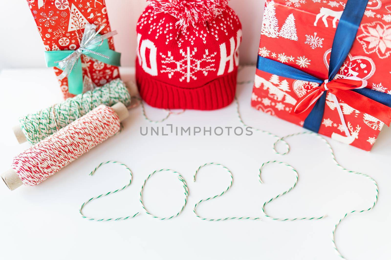 Holiday concept for Christmas and New Year 2022. Layout of various Christmas attributes - hat, sock, striped threads for packaging