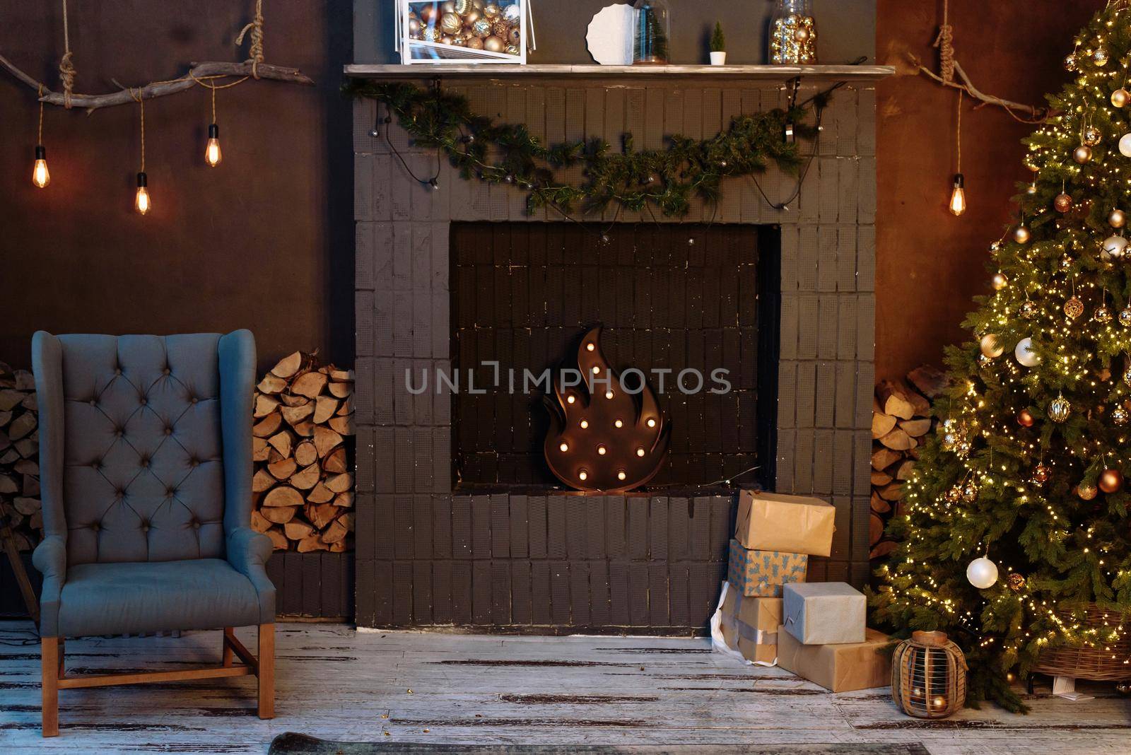 Dark modern interior with Christmas tree and faux fireplace.