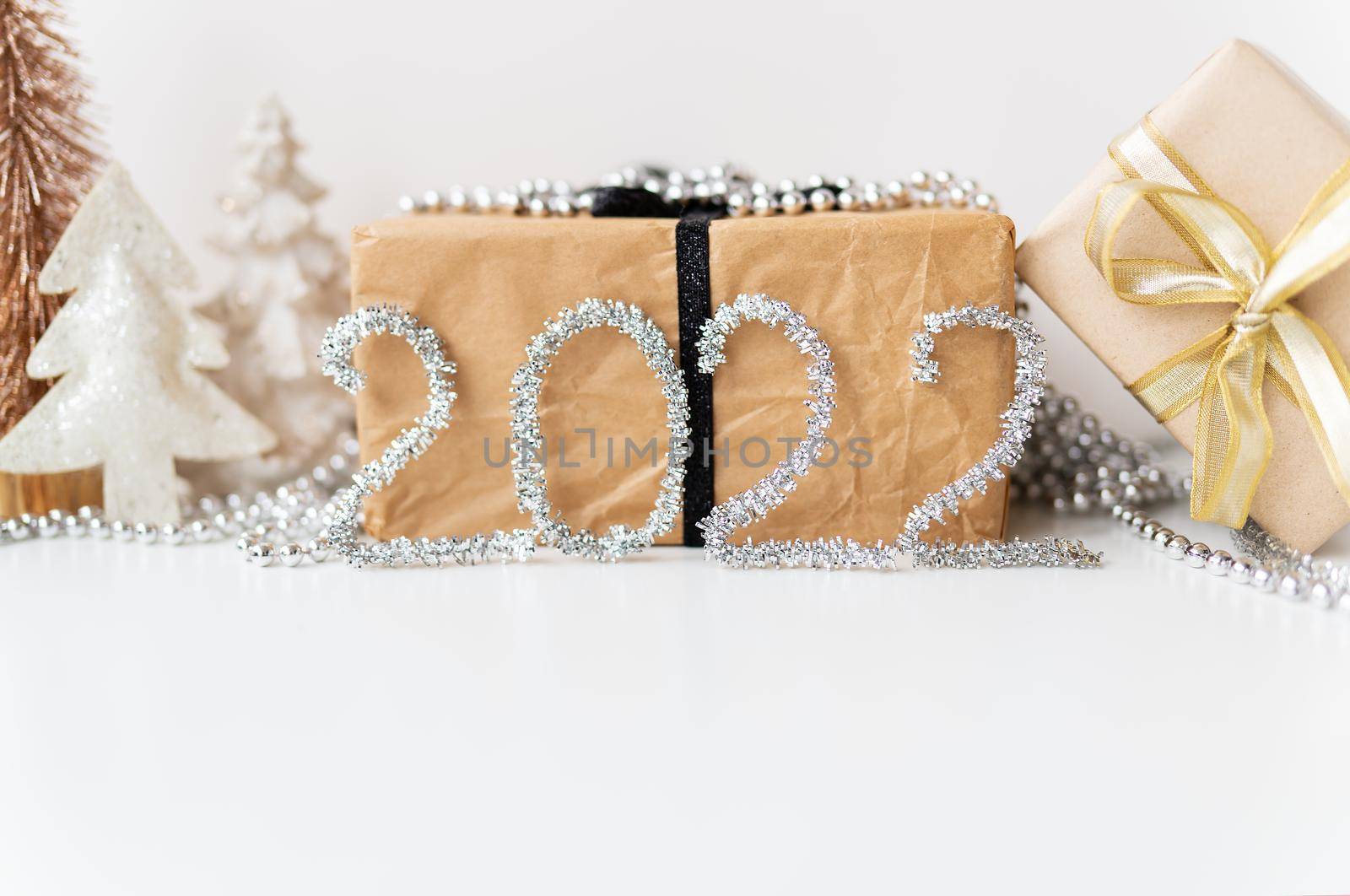Happy New Year 2022. Festive gold decor - a tree, a gift, a star, tinsel. Empty space for an inscription. by sfinks