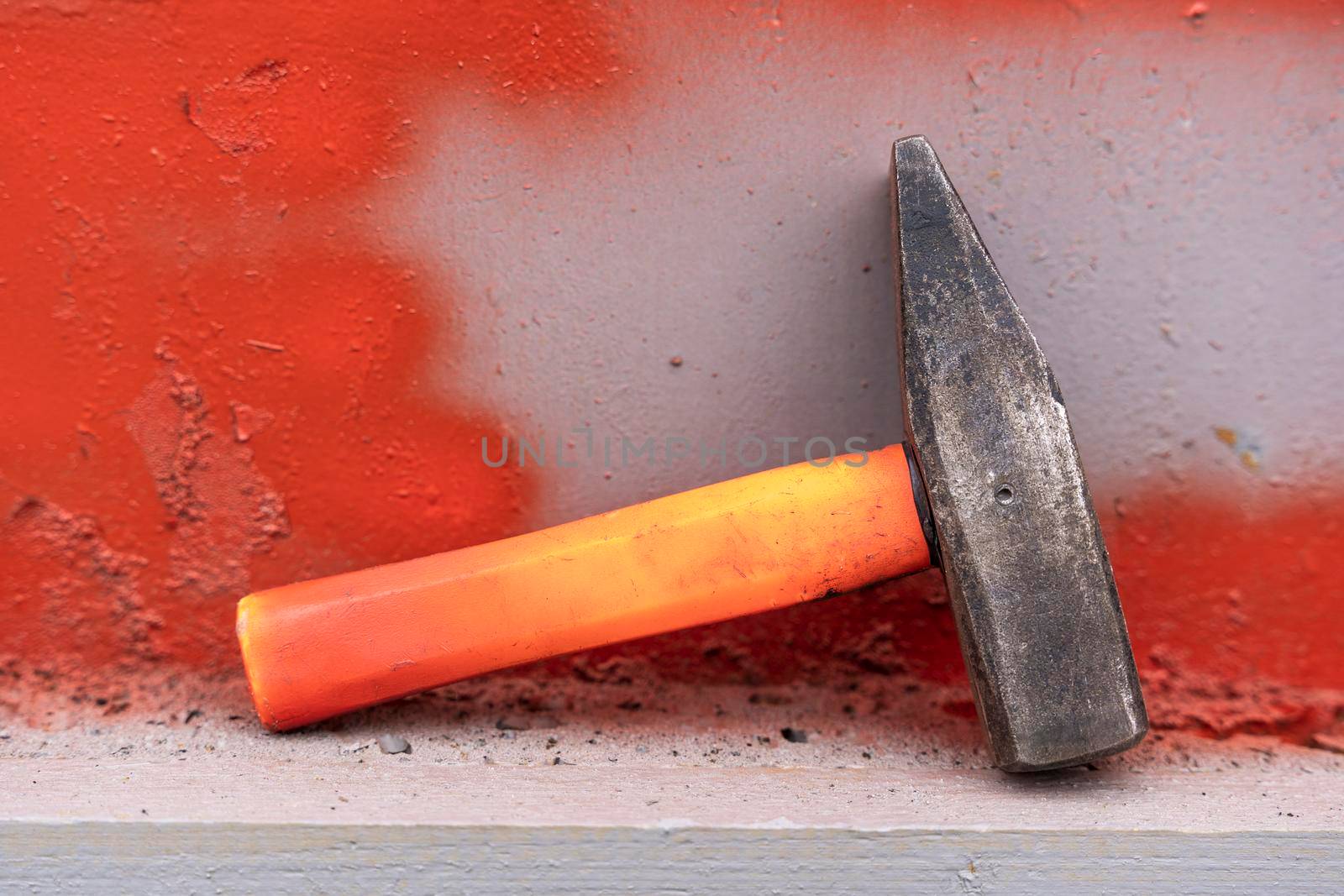 an iron hammer with a short plastic handle on a shelf in the workshop by audiznam2609