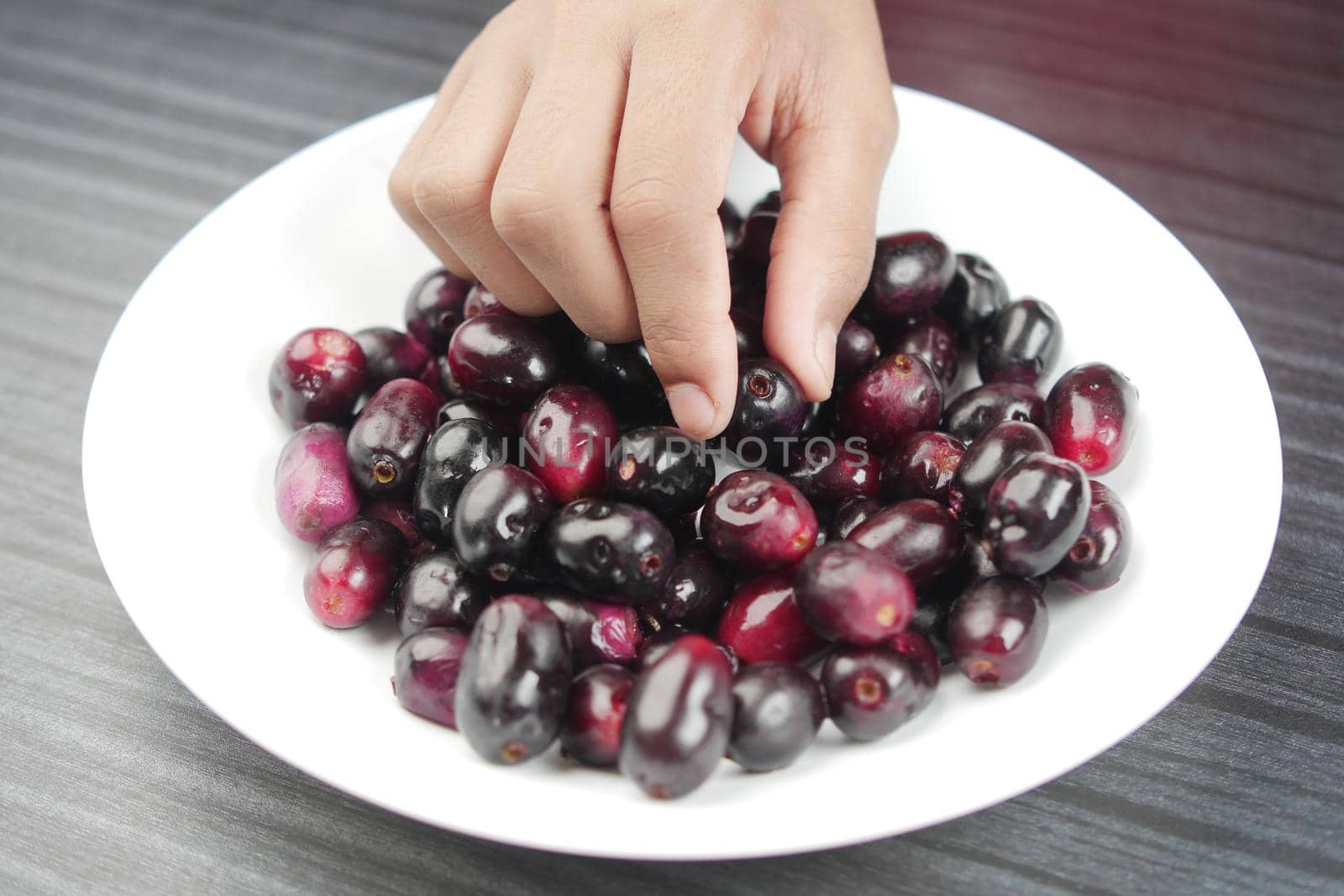 top view of black plum on a plate