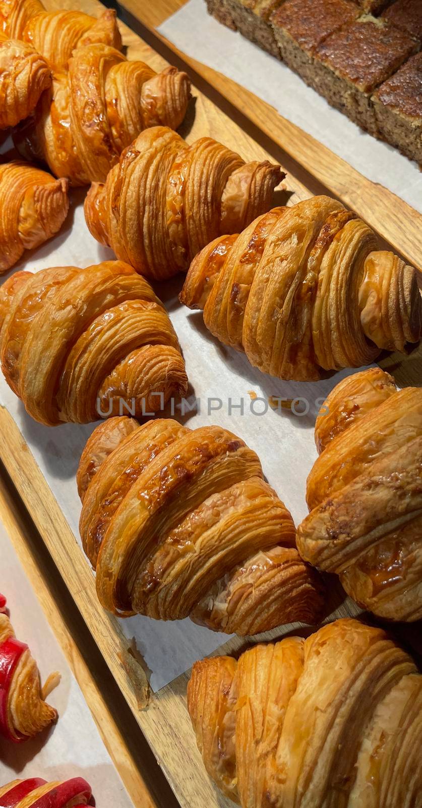 Close up group of fresh baked delicious croissants, super delicious warm fresh buttery Croissants and Rolls, French and American Croissants and baked pastries are enjoyed world wide on bakery shop, tasty multiple croissant
