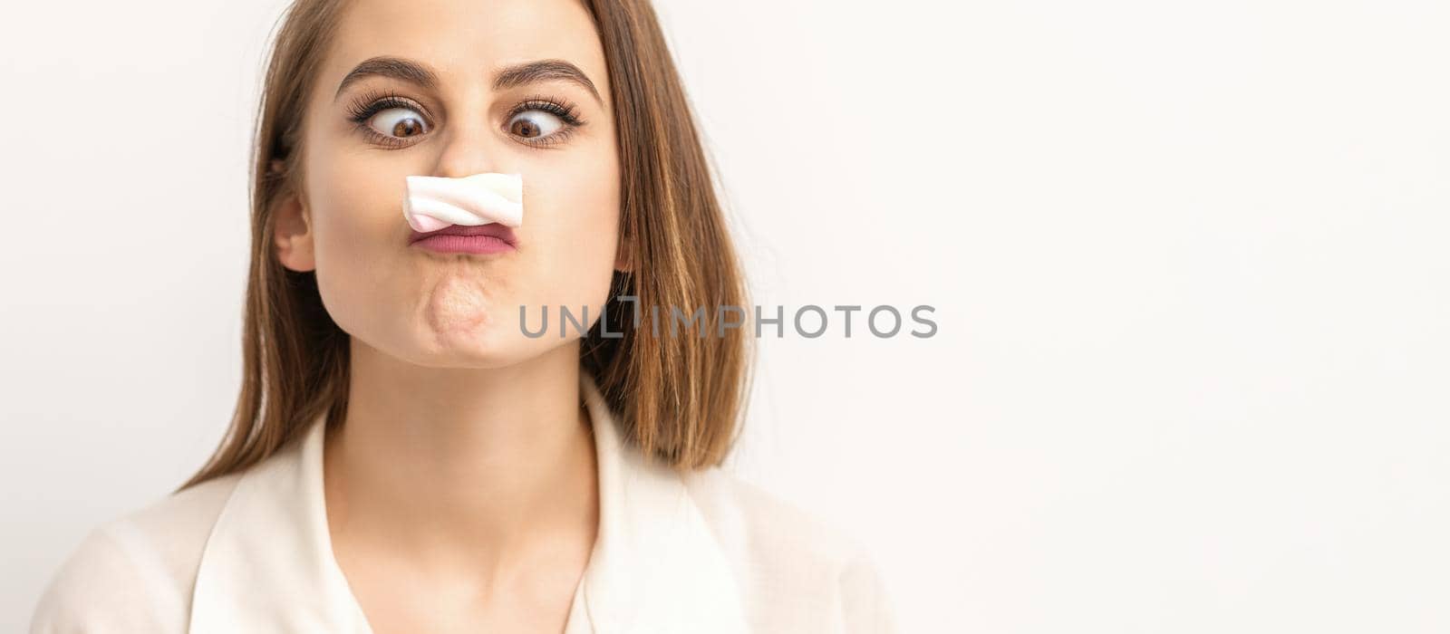 Young funny woman with sweet candy marshmallow-like mustache over white background. Depilation and epilation concept