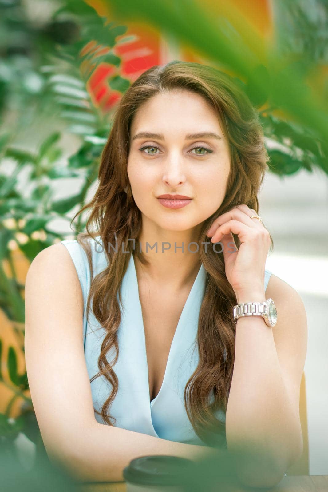 Portrait of a beautiful young caucasian woman sitting in flower garden outdoors