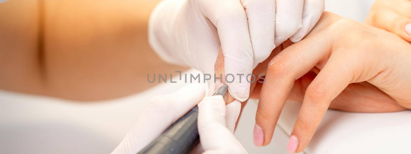 Manicurist removing old nail polish by okskukuruza