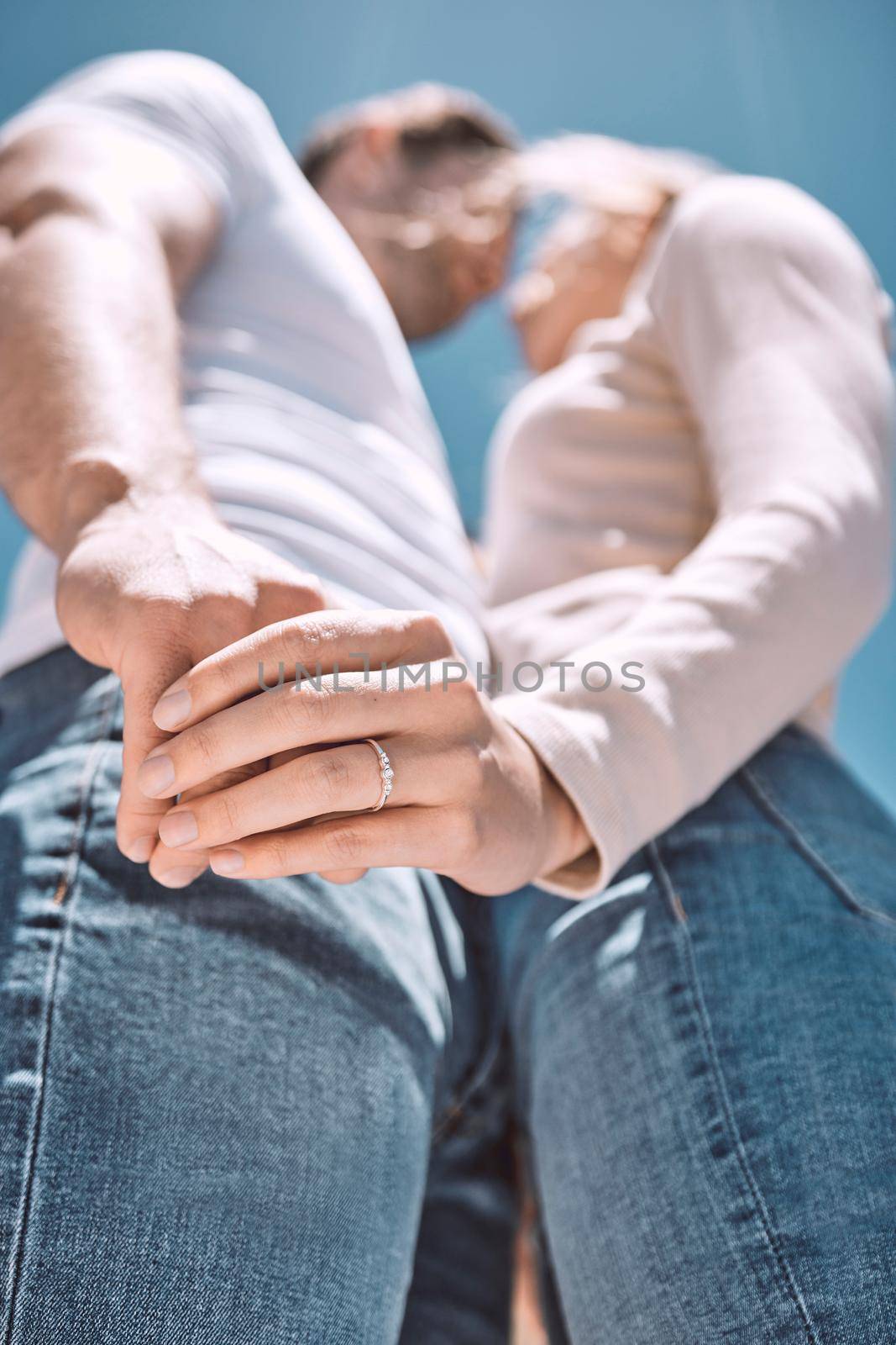 Engagement, romance and in love couple holding hands with ring on finger while celebrating relationship anniversary, wedding or honeymoon together outdoors. Below of husband and wife showing love.