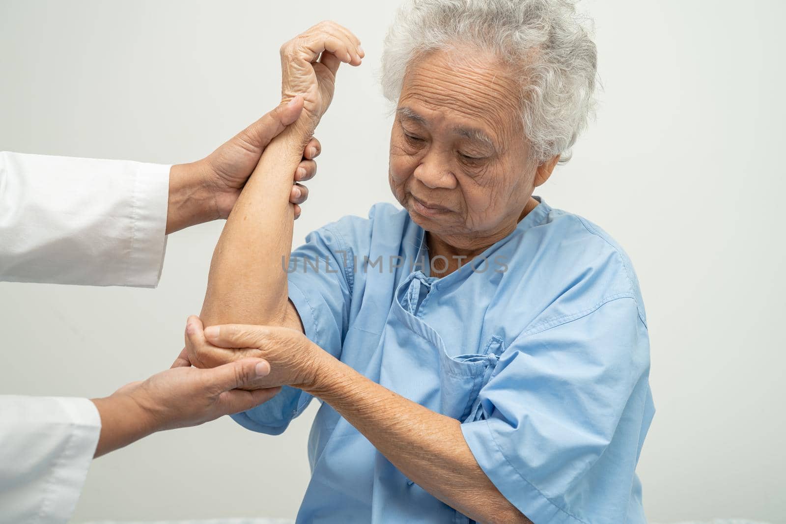 Asian senior or elderly old lady woman patient feel pain her elbow on bed in nursing hospital ward, healthy strong medical concept.
