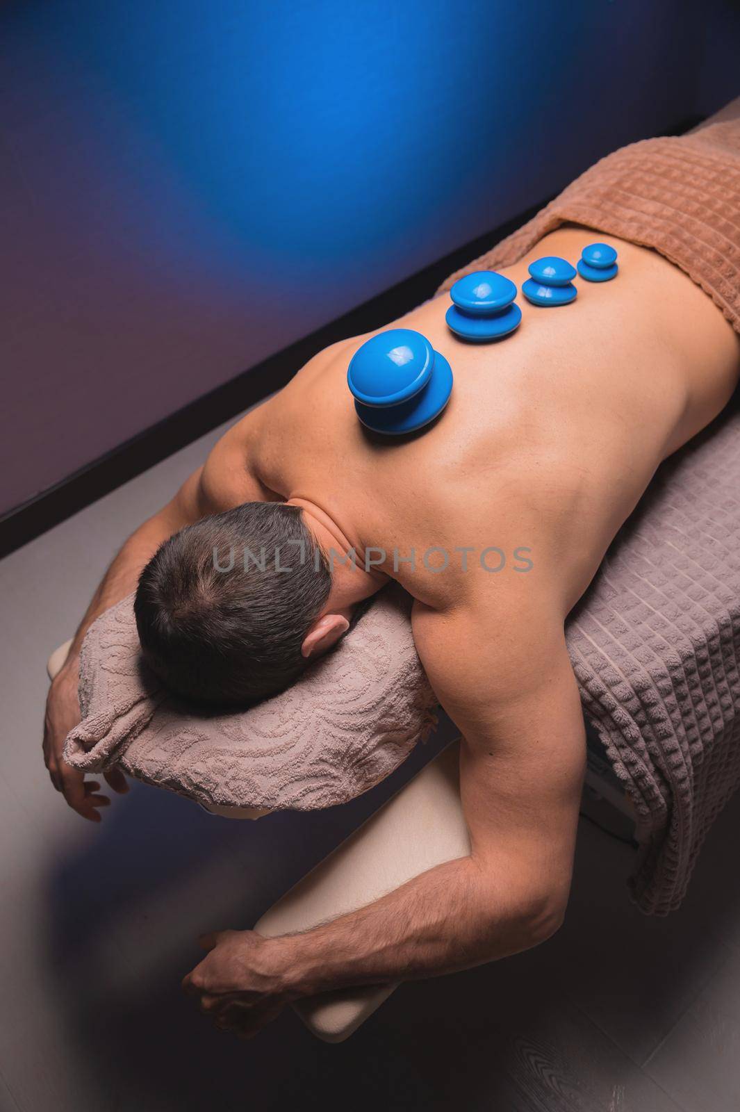 Massage vacuum rubber cans. Close-up of a relaxed man lying with jars on his back in a spa by yanik88