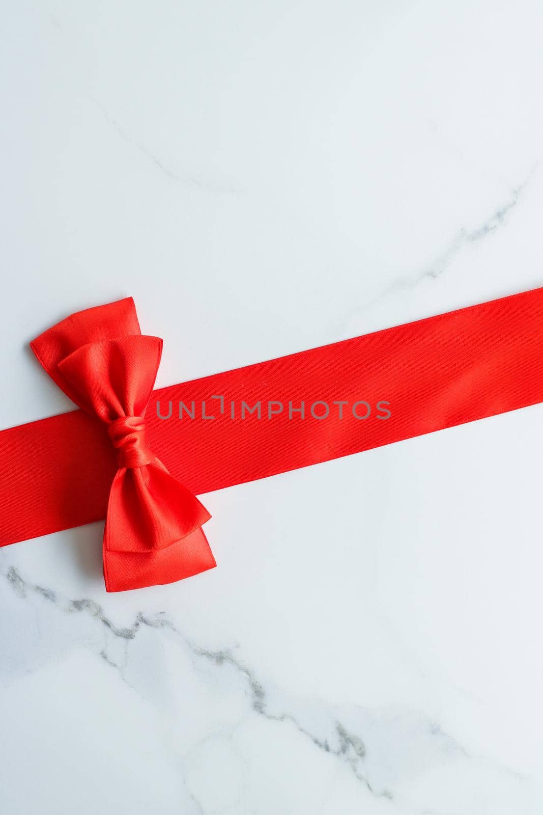 Red silk ribbon on marble, top view by Anneleven