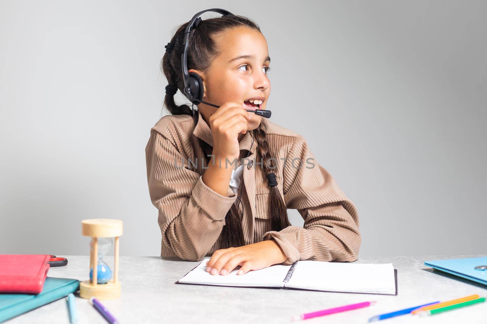 E-Learning. Shocked Little Schoolgirl Looking At Laptop Wearing Headphones Looking At Computer Web Camera In Shock Making Video Call And Learning Online At Home. Shocking News Concept