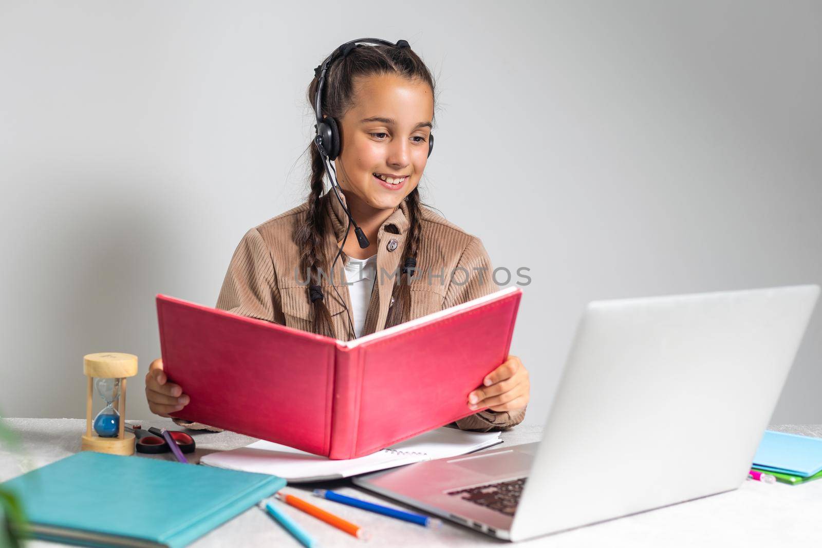 Online Education. Cute little Girl Study At Home With Laptop And Wireless Headphones, Adorable Kid Having Web Lesson With Teacher, Enjoying Distance Learning During Quarantine Time, Free Space by Andelov13