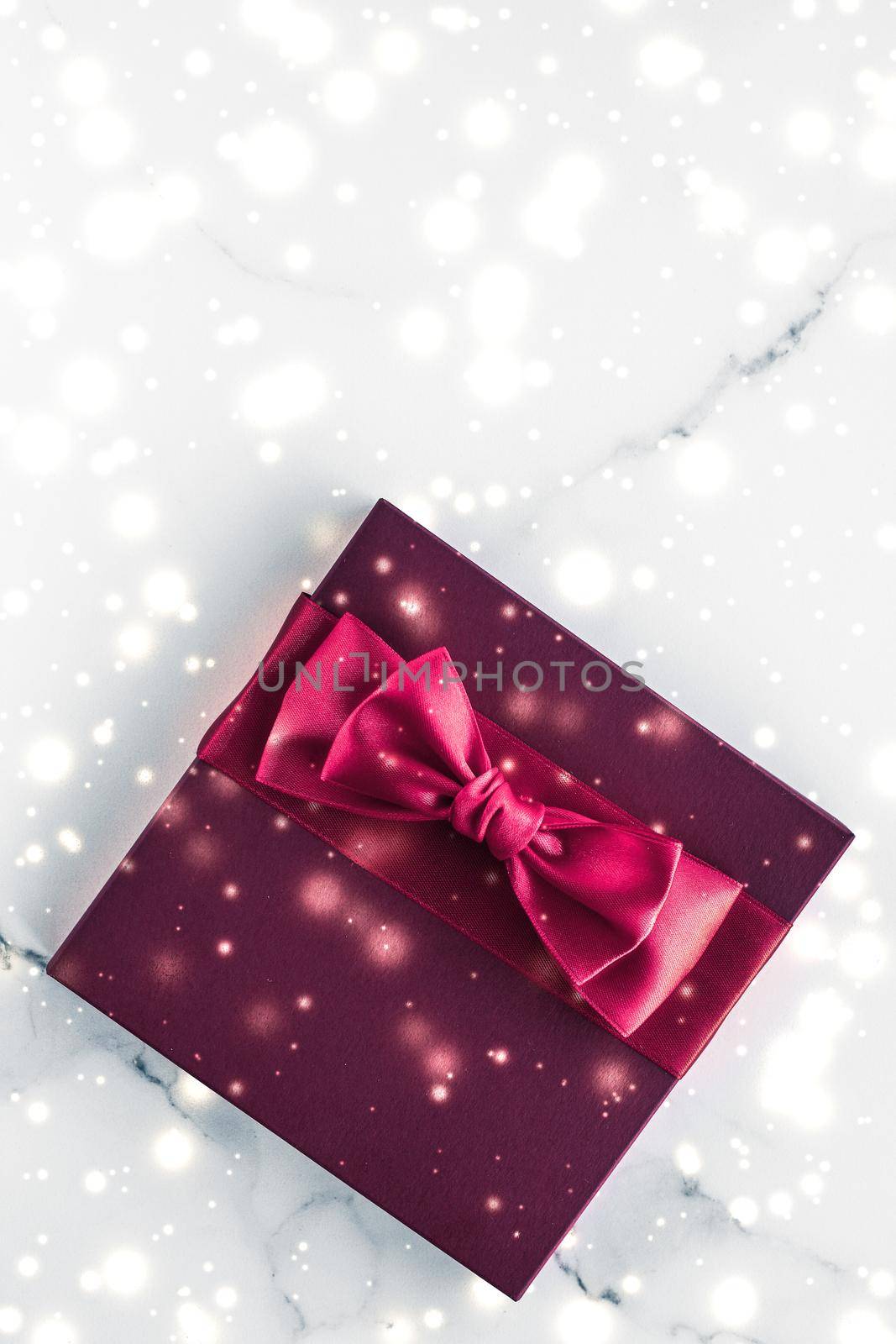 New Years Eve celebration, wrapped luxury boxes and cold season concept - Winter holiday gifts with cherry silk bow and glowing snow on frozen marble background, Christmas presents surprise