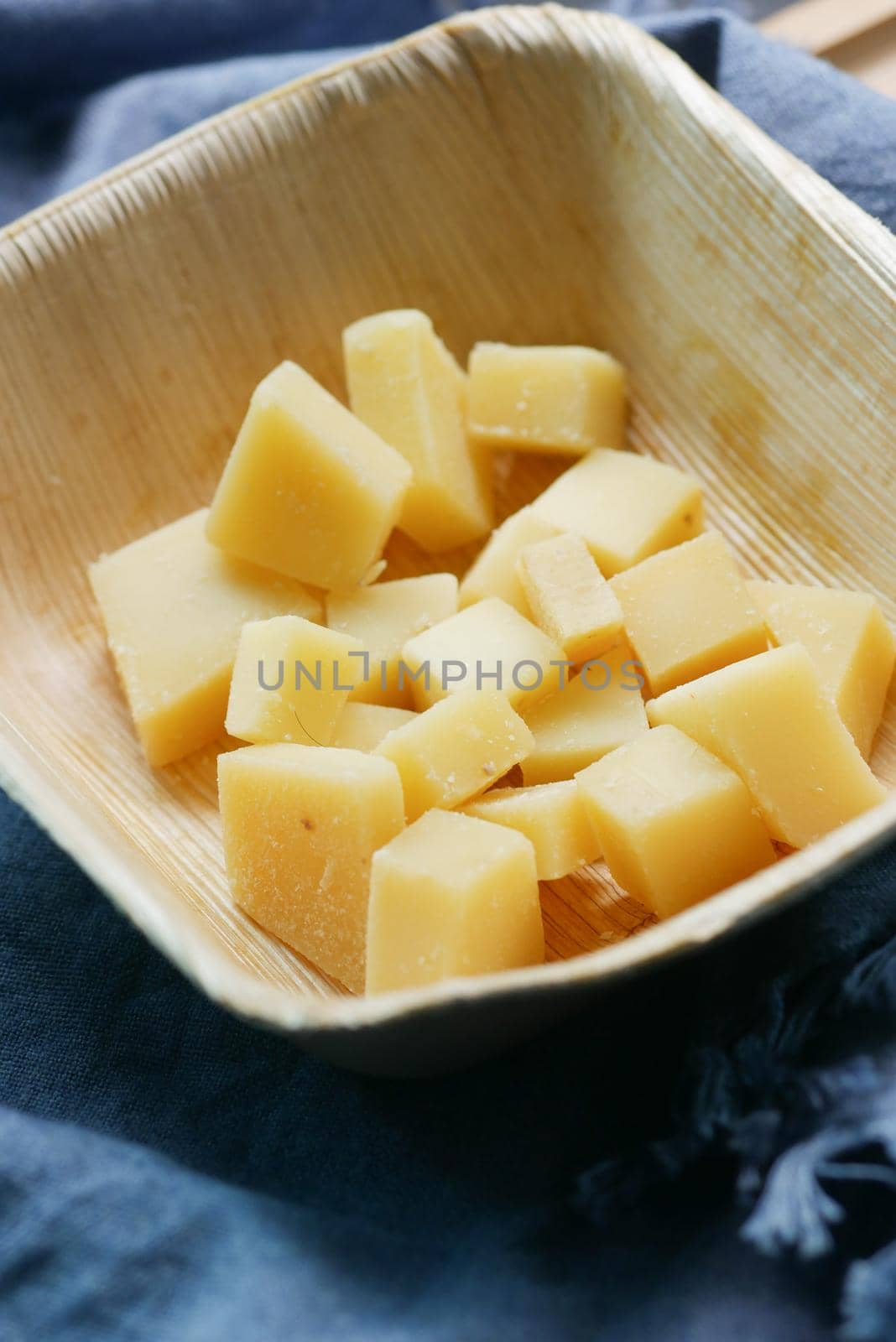 close up of cube shape fresh cheese on in a bowl .