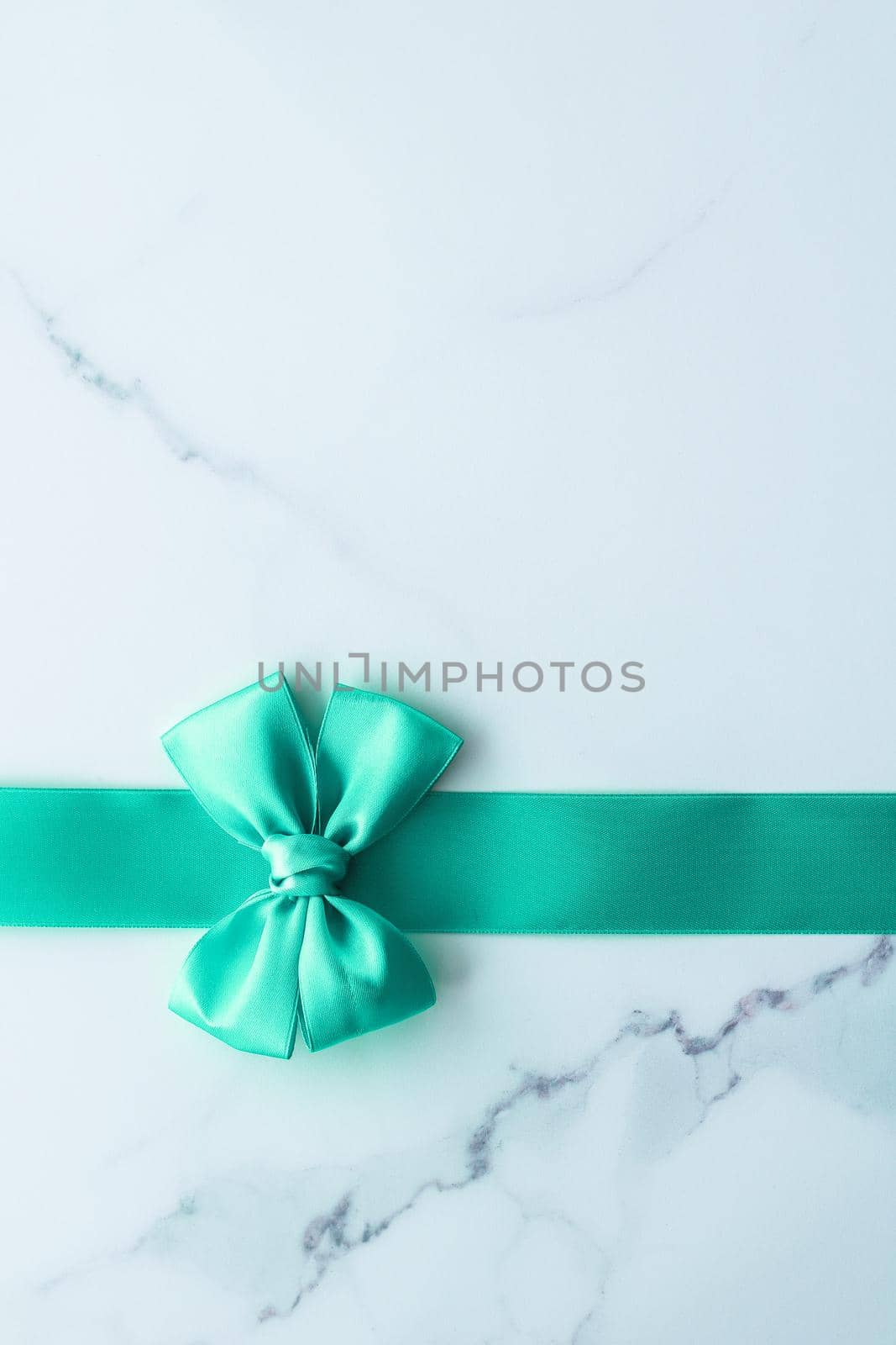 Green silk ribbon on marble background, top view by Anneleven