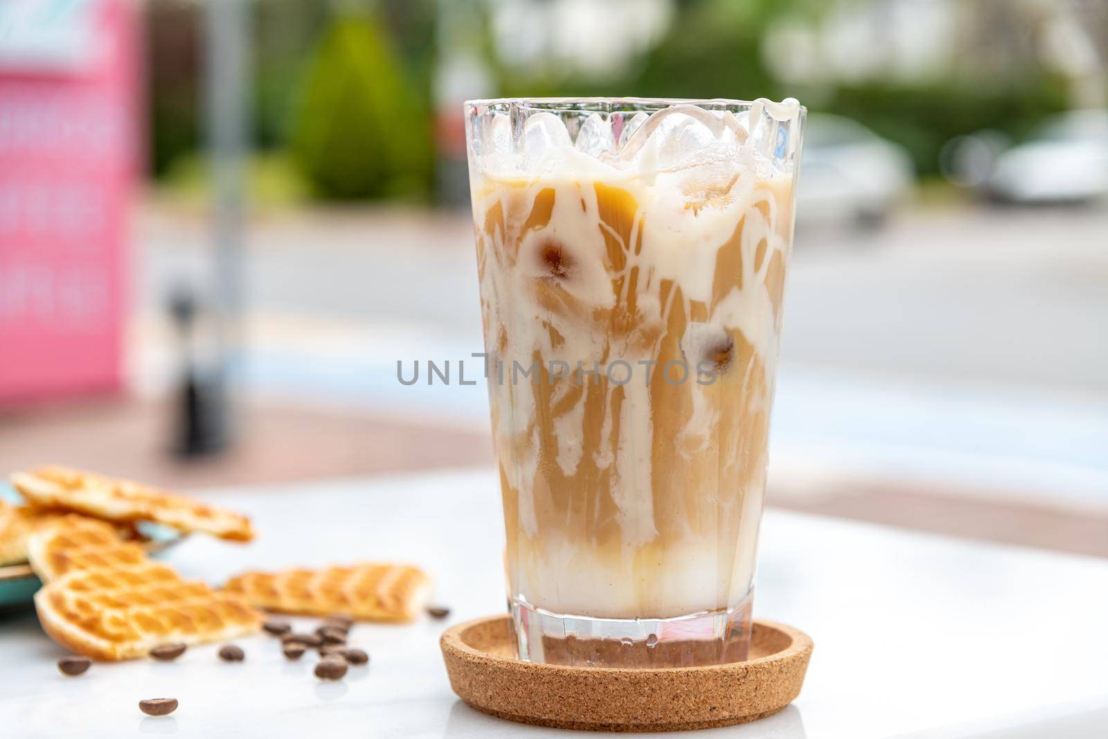 Iced caramel latte coffee in a tall glass with caramel syrup