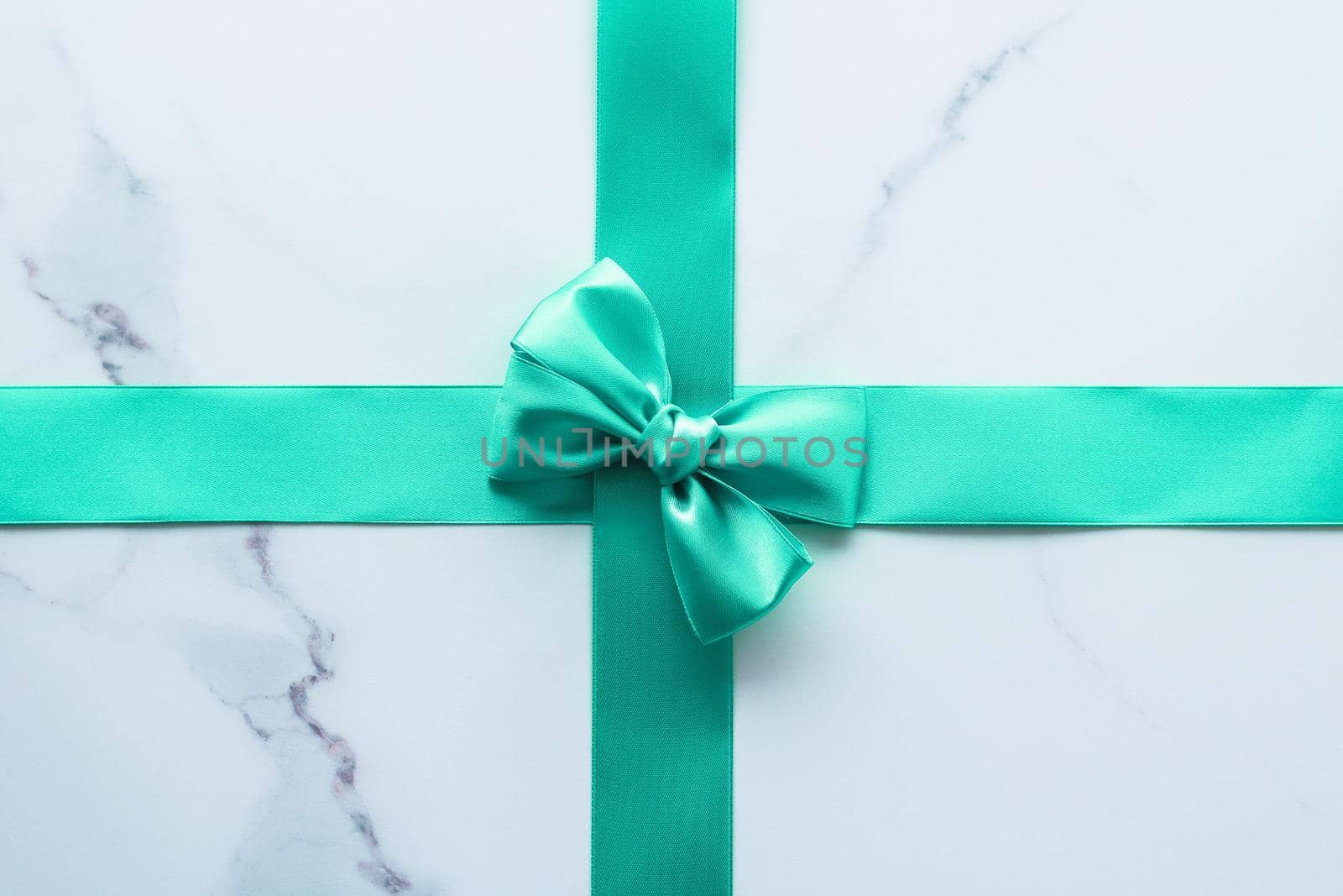 Holiday design, greeting card and vintage gift concept - Green silk ribbon on marble background, top view