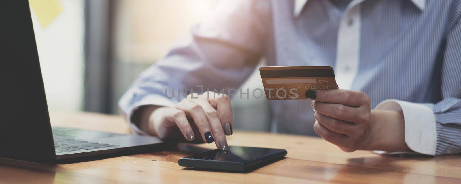 Hands holding credit card and using mobile smart phone with morning, Online shopping..