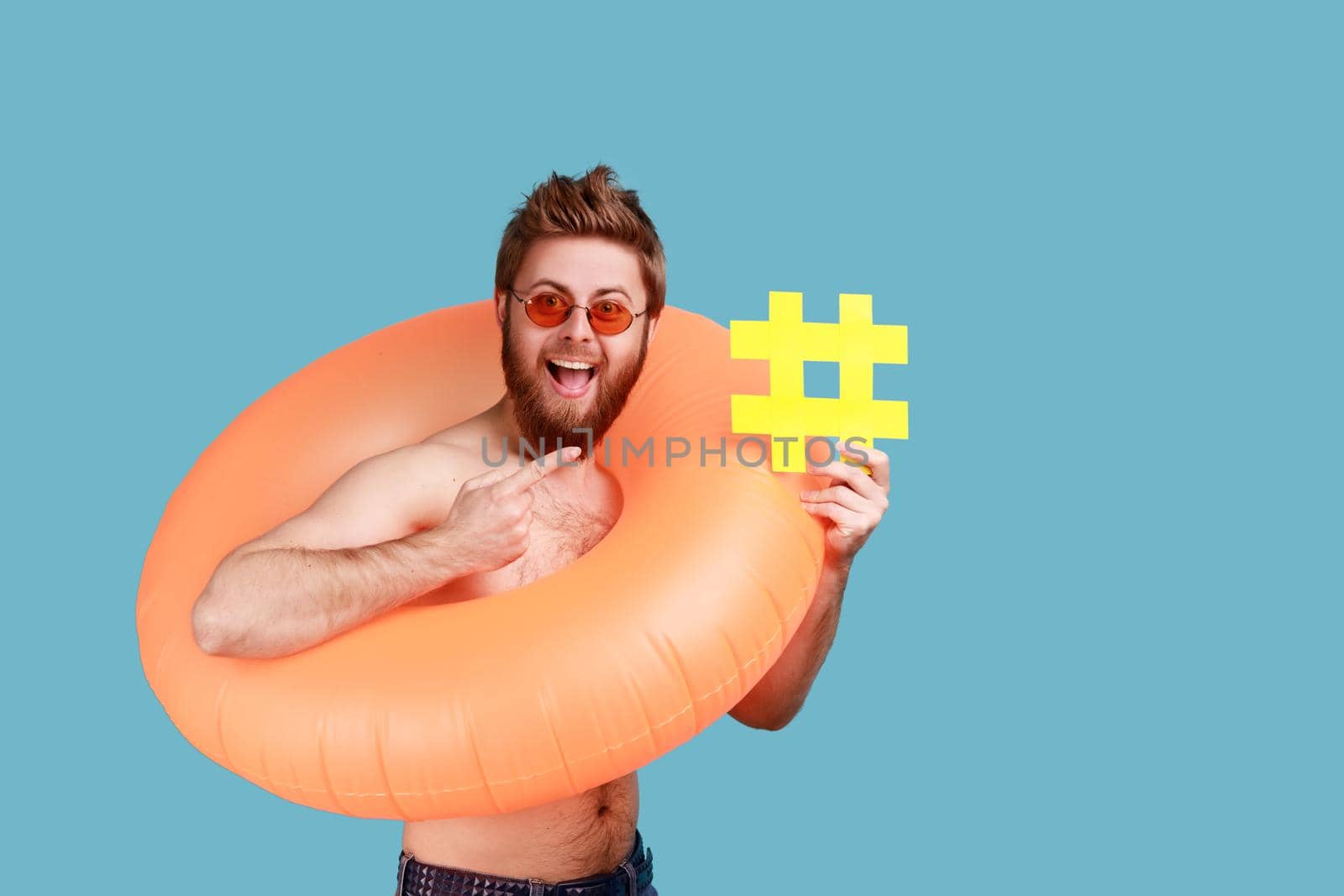 Man standing with orange rubber ring, pointing at yellow hashtag symbol, hash sign of viral web idea by Khosro1