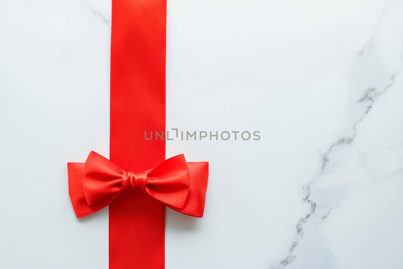 Red silk ribbon on marble, top view by Anneleven