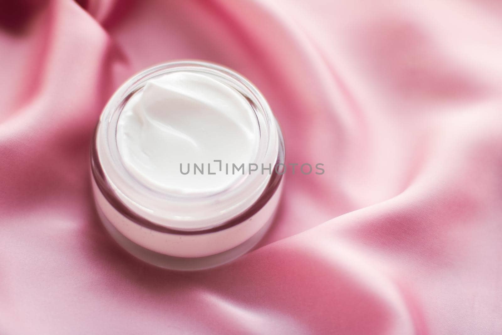 Beauty, anti-age cosmetics and skincare concept - Luxury face cream jar on a soft pink silk