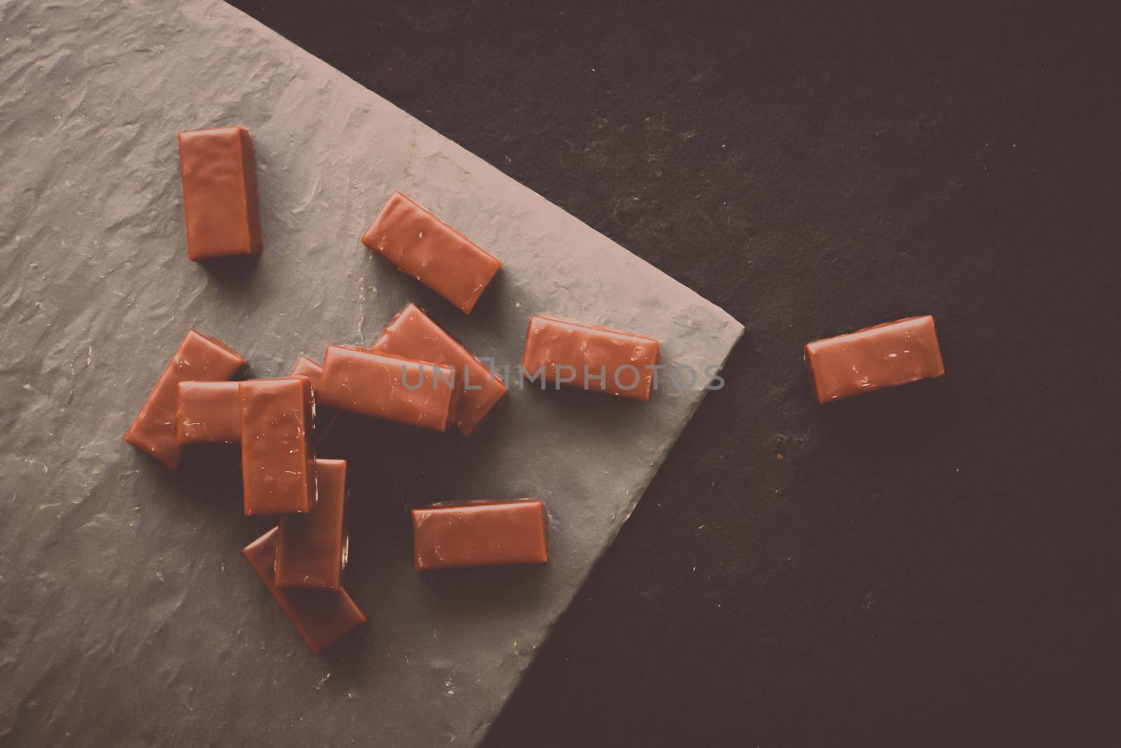 Sweet swiss chocolate candies on a stone tabletop, flatlay - desserts, confectionery and gluten-free organic food concept. All you need is chocolate