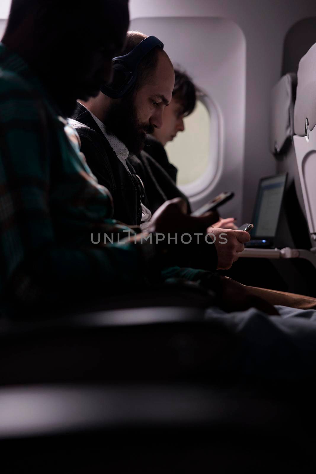 Multiethnic passengers flying in economy class with airplane by DCStudio