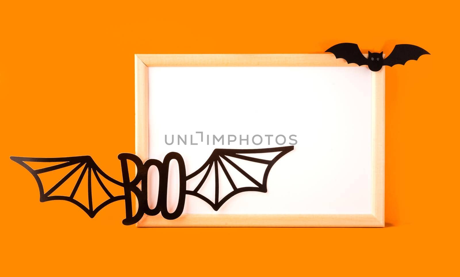 Happy halloween holiday concept. Halloween handmade paper decorations, boo text, bat, frame on orange background. Halloween festival party, greeting card mockup blank with copy space.