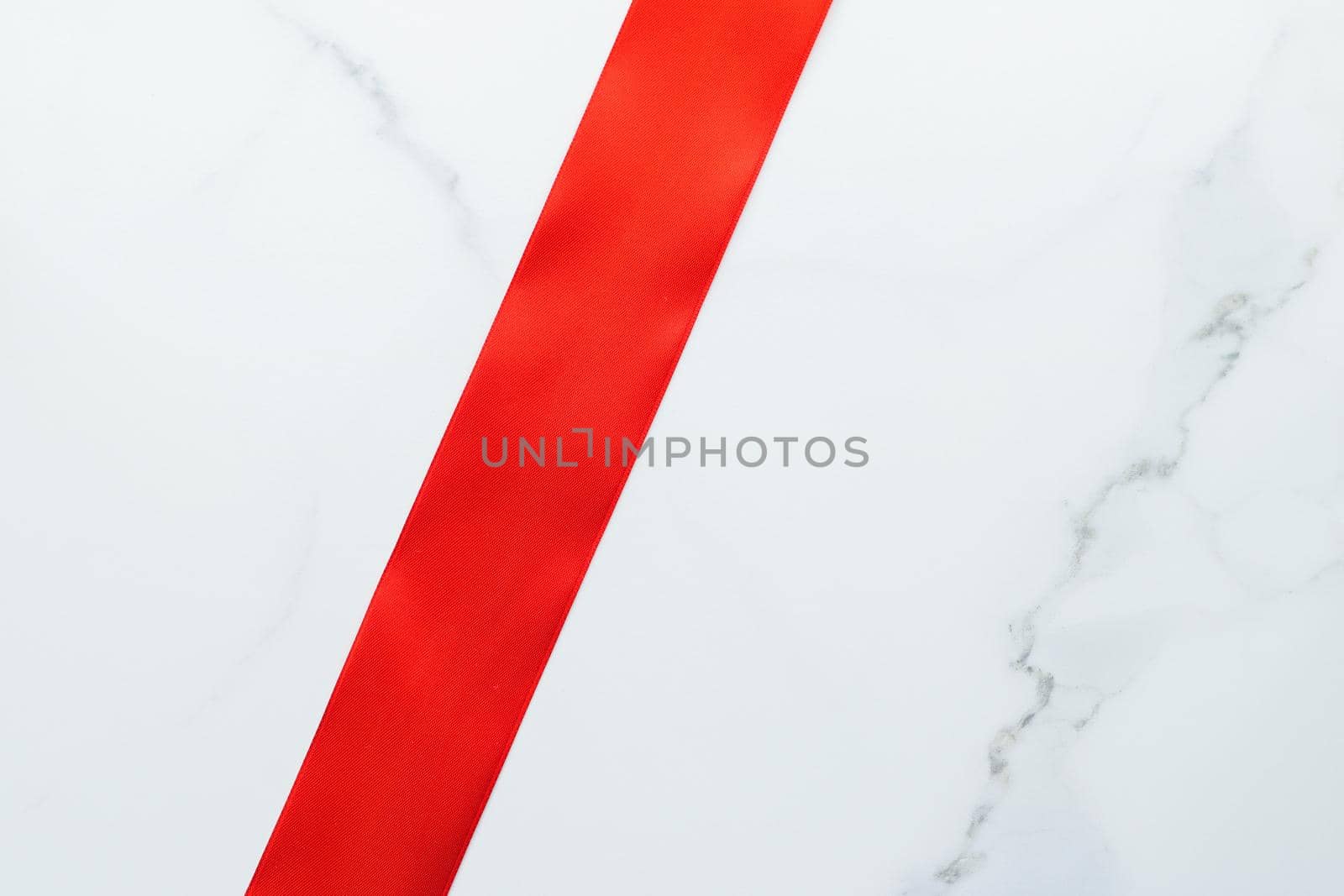 Red silk ribbon on marble, top view by Anneleven