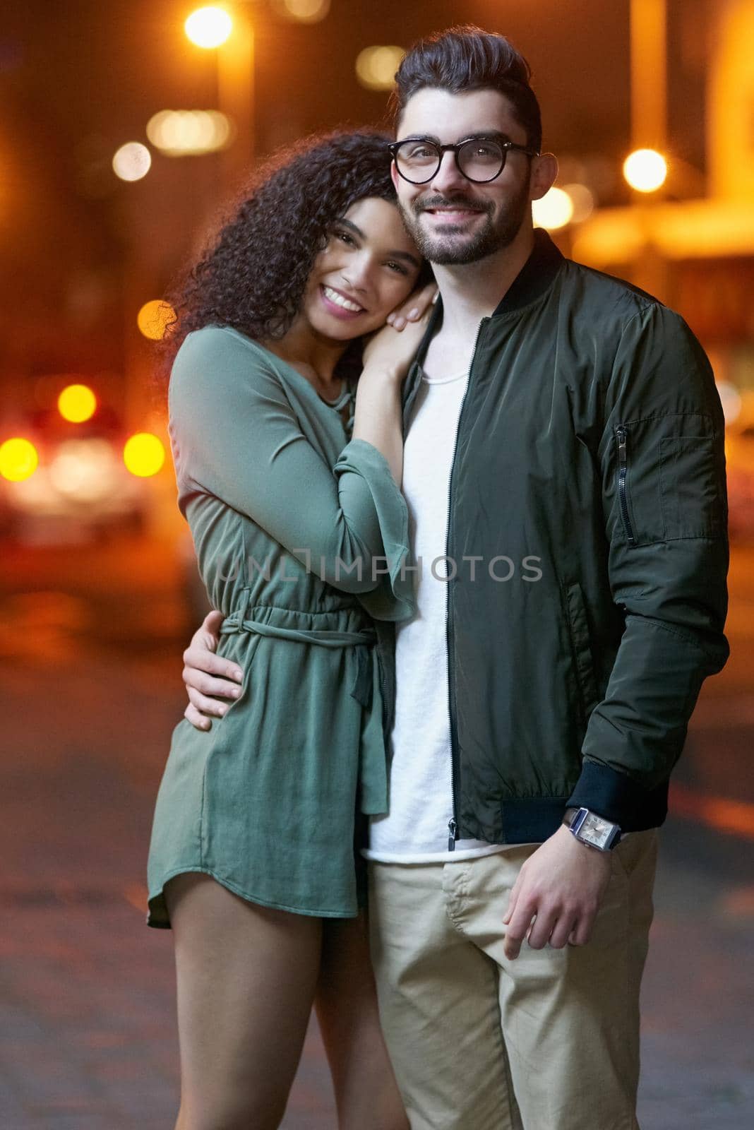 The perfect couple. Portrait of a happy young couple outdoors at night. by YuriArcurs