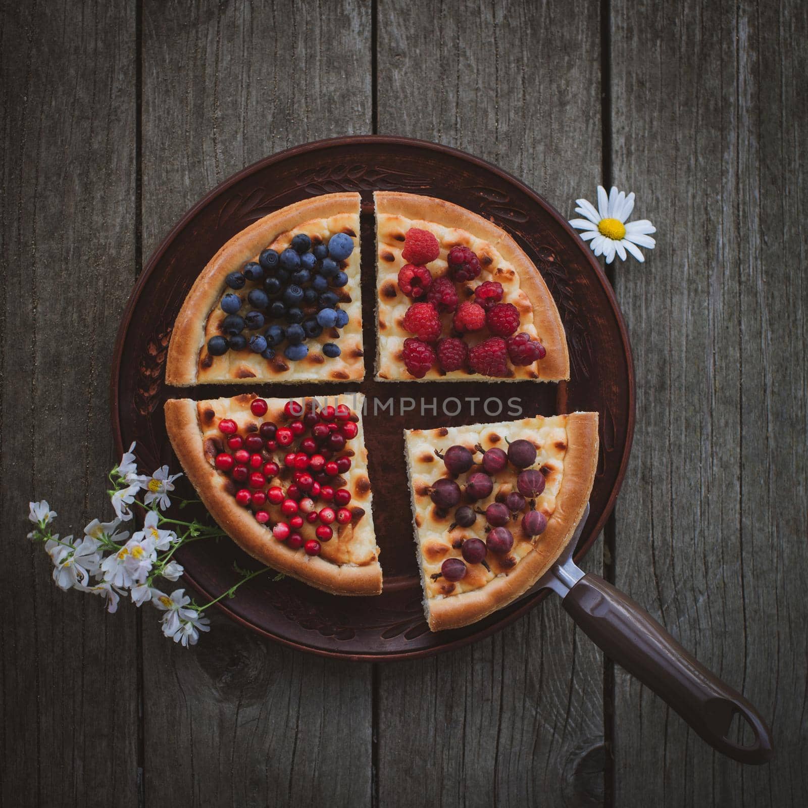 Homemade cheesecake Pie with berries and flowers On plate on Wooden Background
