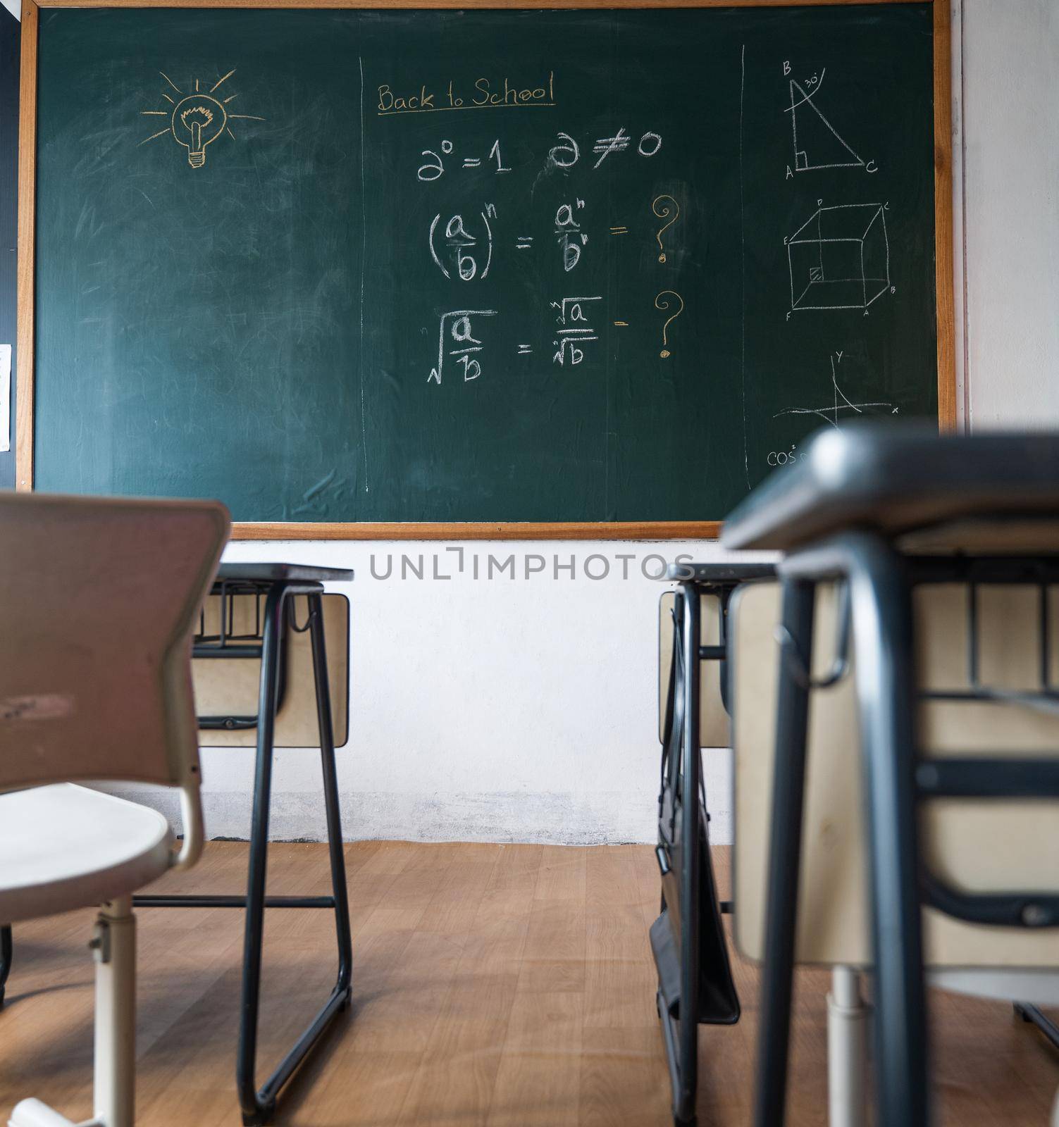 Empty classroom with chairs elementary school desks and chalkboard by Sorapop