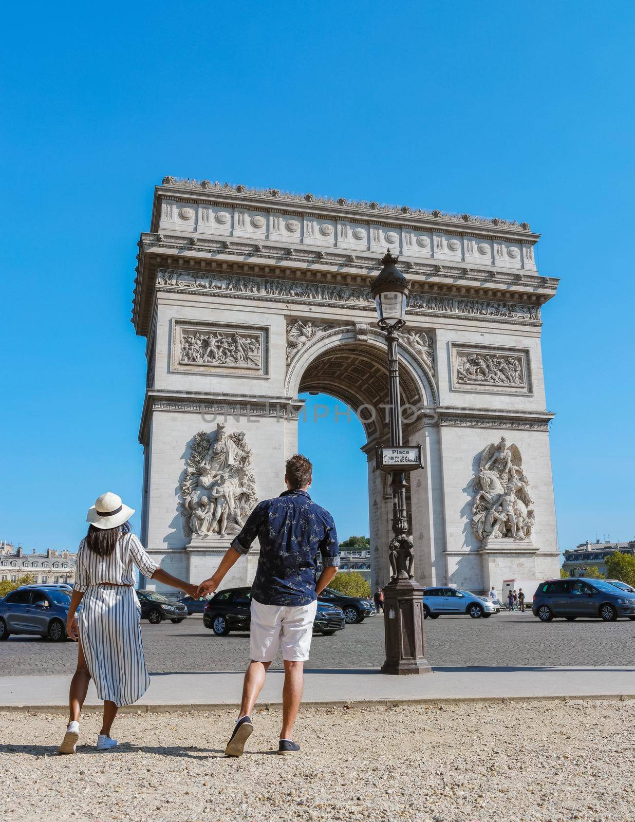 Couple on a citytrip in Paris visiting Avenue des Champs-Elysees Paris France Arc De Triomphe by fokkebok