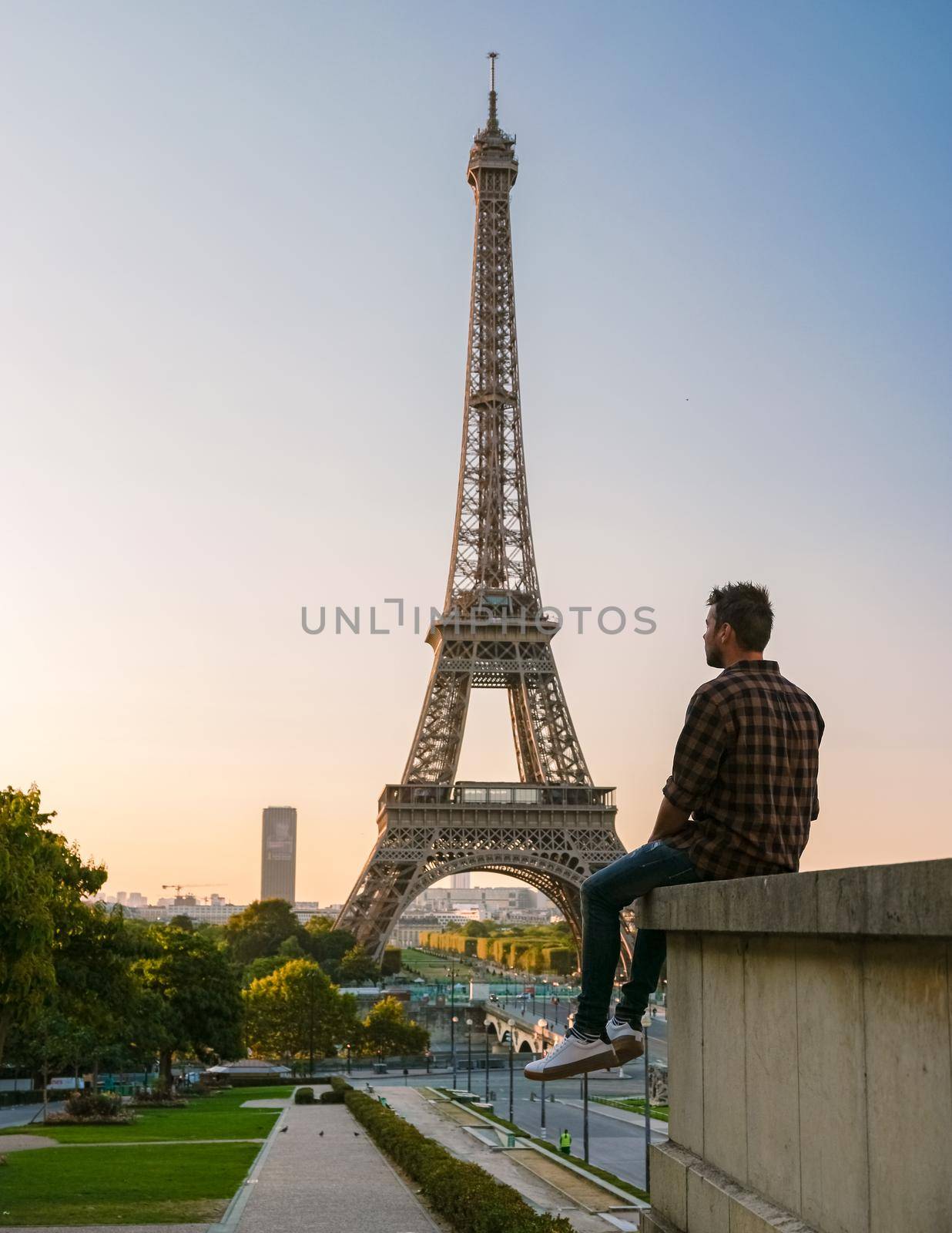 Young men watching sunrise by the Eiffel tower, Eiffel tower at Sunrise in Paris France, Paris Eifel tower on a summer day in the city of Paris France