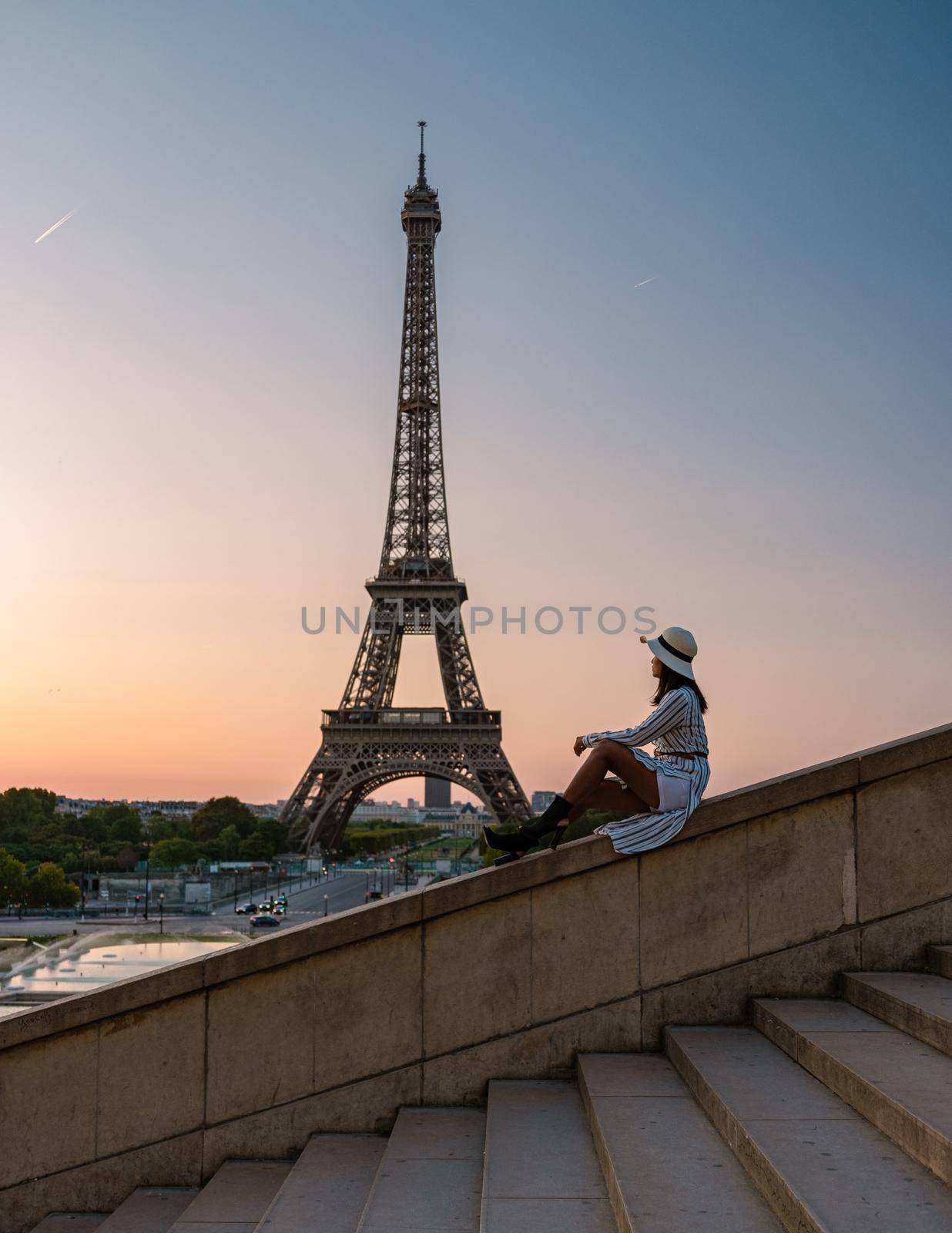 Young women with a hat visiting Eiffel tower at Sunrise in Paris France, Paris Eifel tower on a summer day in the city of Paris France