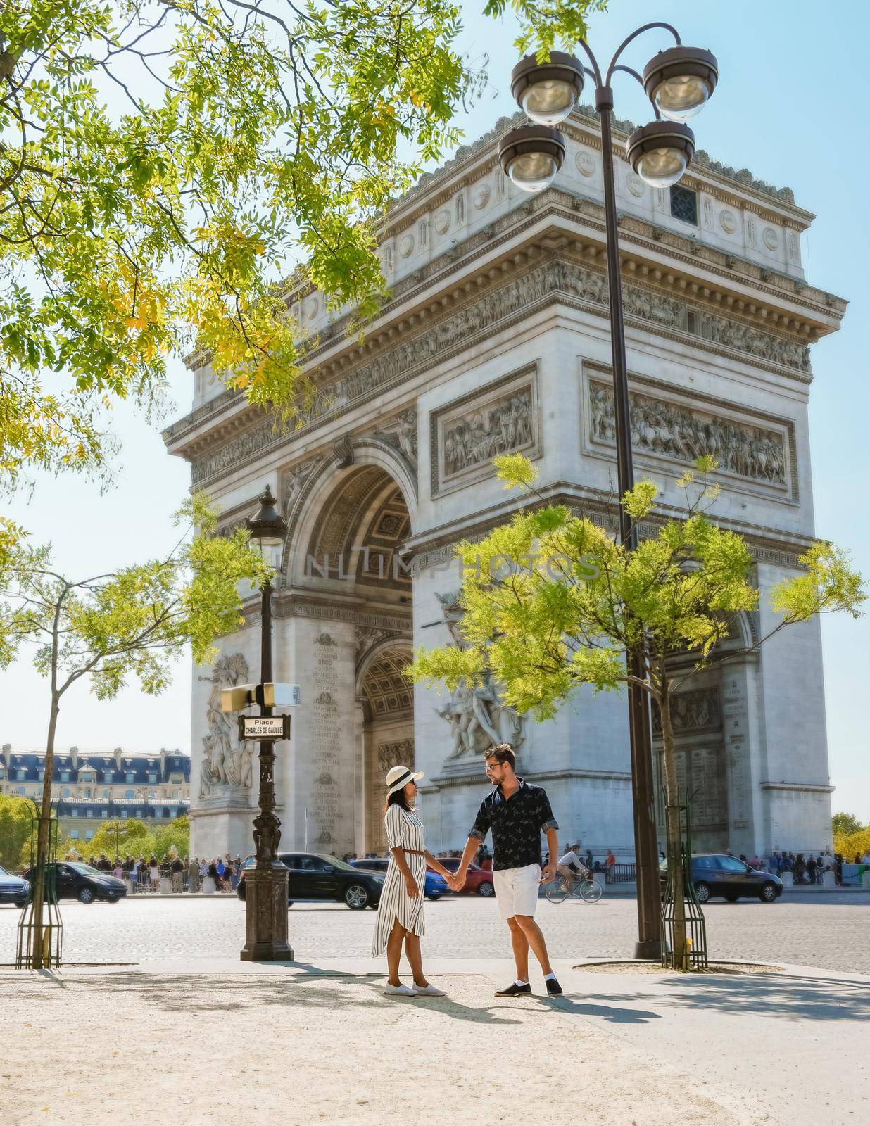 Couple on a citytrip in Paris visiting Avenue des Champs Elysees Paris France Arc De Triomphe. Men and women visiting Arc de Triomphe in Paris