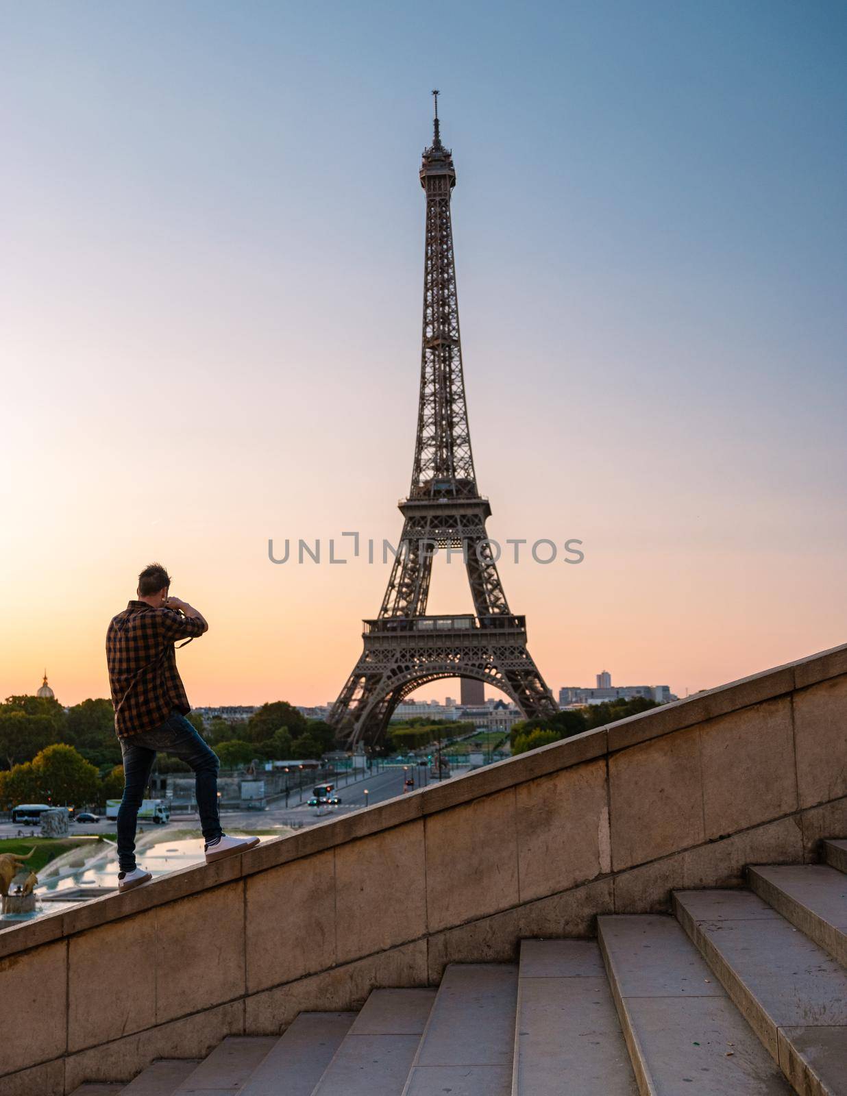 Young men watching sunrise by the Eiffel tower, Eiffel tower at Sunrise in Paris France, Paris Eifel tower on a summer day in the city of Paris France