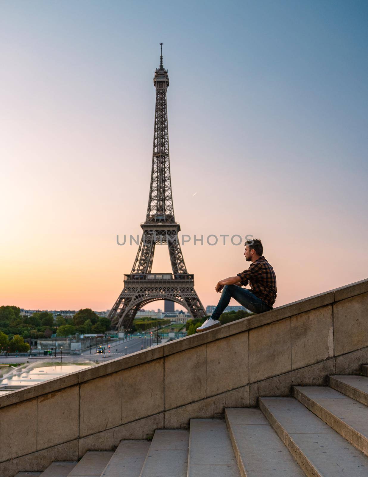 Young men watching sunrise by the Eiffel tower, Eiffel tower at Sunrise in Paris France, Paris Eifel tower on a summer day in the city of Paris France