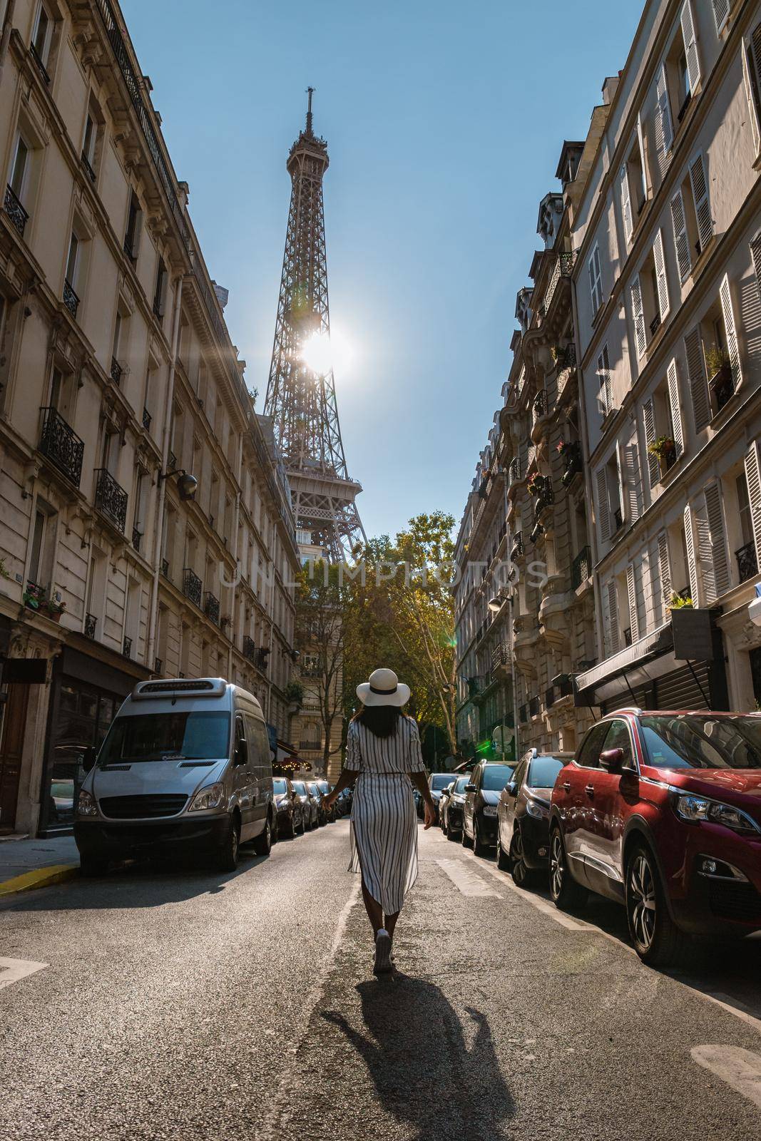 Young women with a hat visiting Eiffel tower at Sunrise in Paris France, Paris Eifel tower on a summer day in the city of Paris France