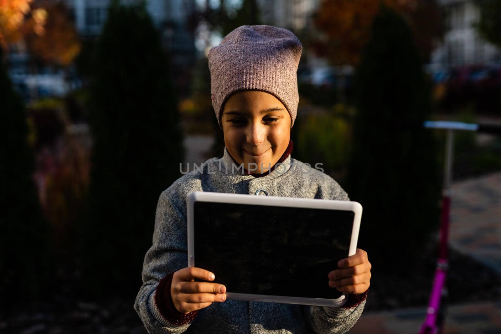 Happy little girl using tablet computer by Andelov13