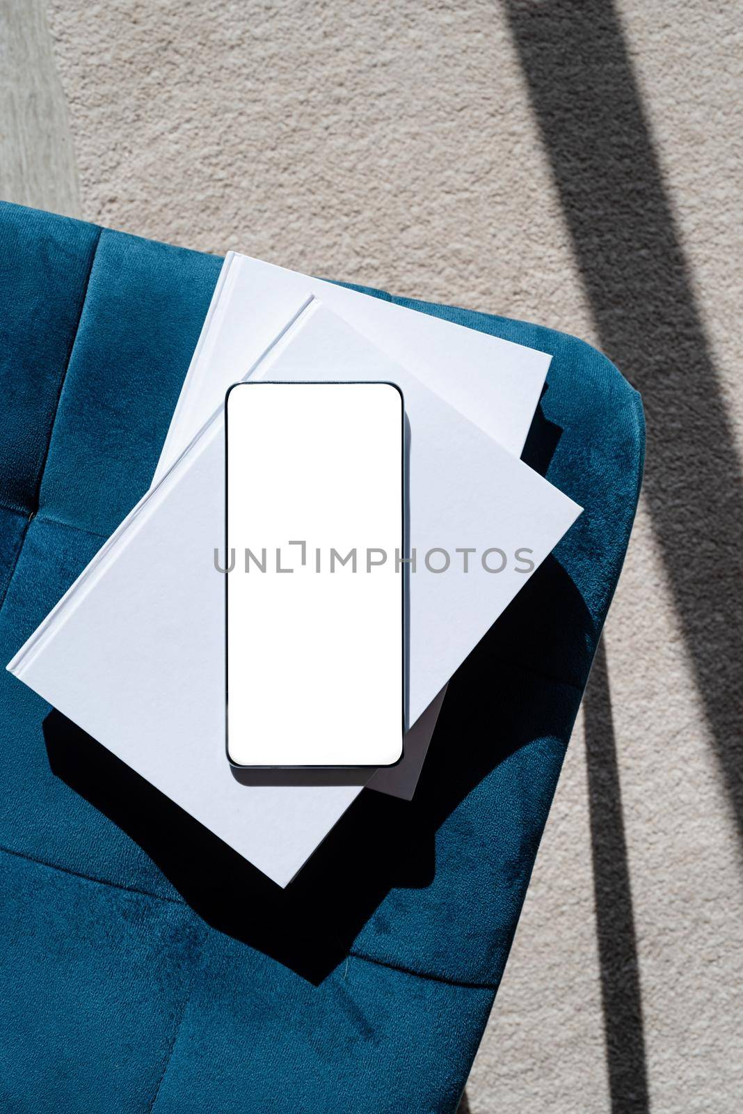 smartphone with isolated screen on blue chair for mockup design. At home interior.