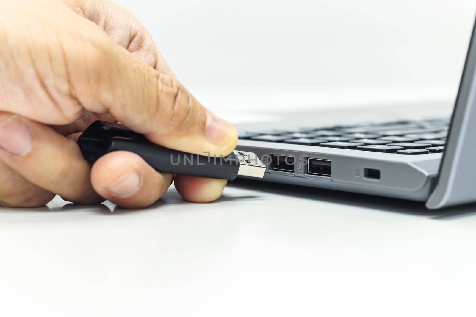 Hand of Businessman push the USB Drive to USB Port for Laptop transfer data or save data 