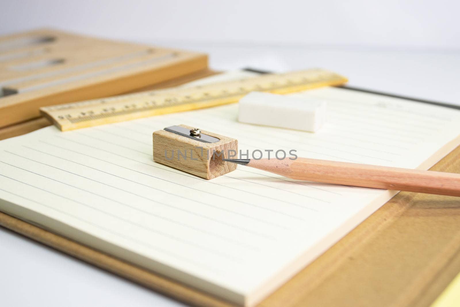 close up a pencil with pencil sharpener on paper and eraser ruler background 