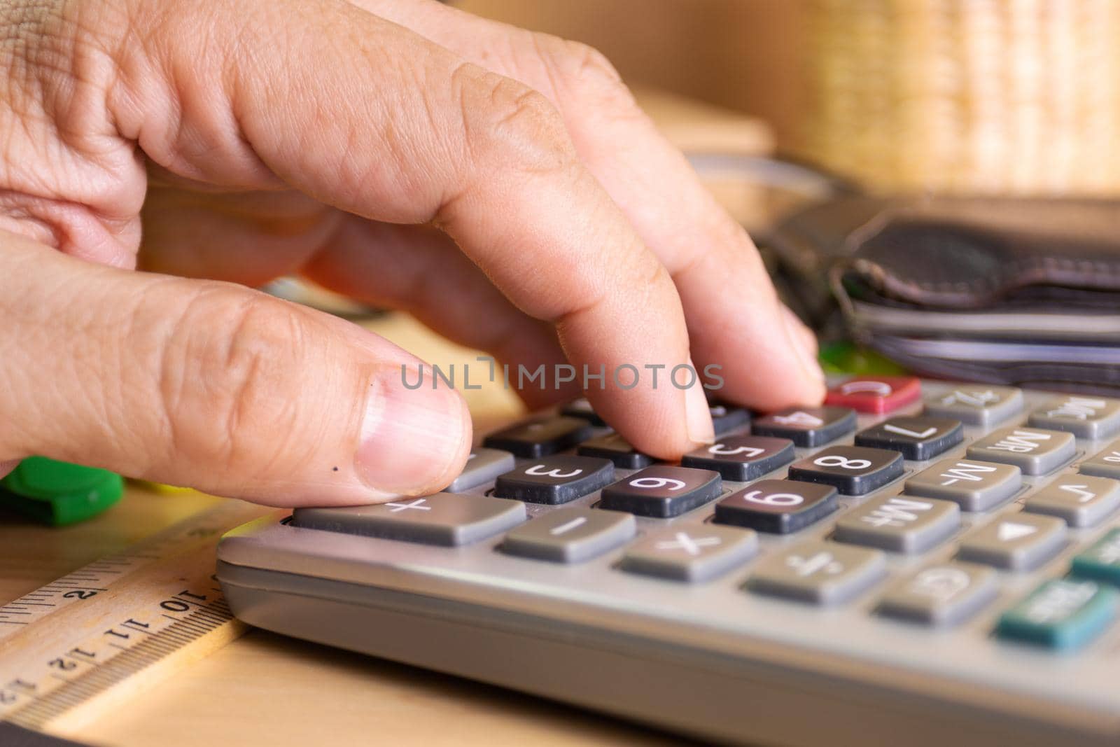 close up human finger push number button of calculator concept Calculation of income, expenditure, calculation