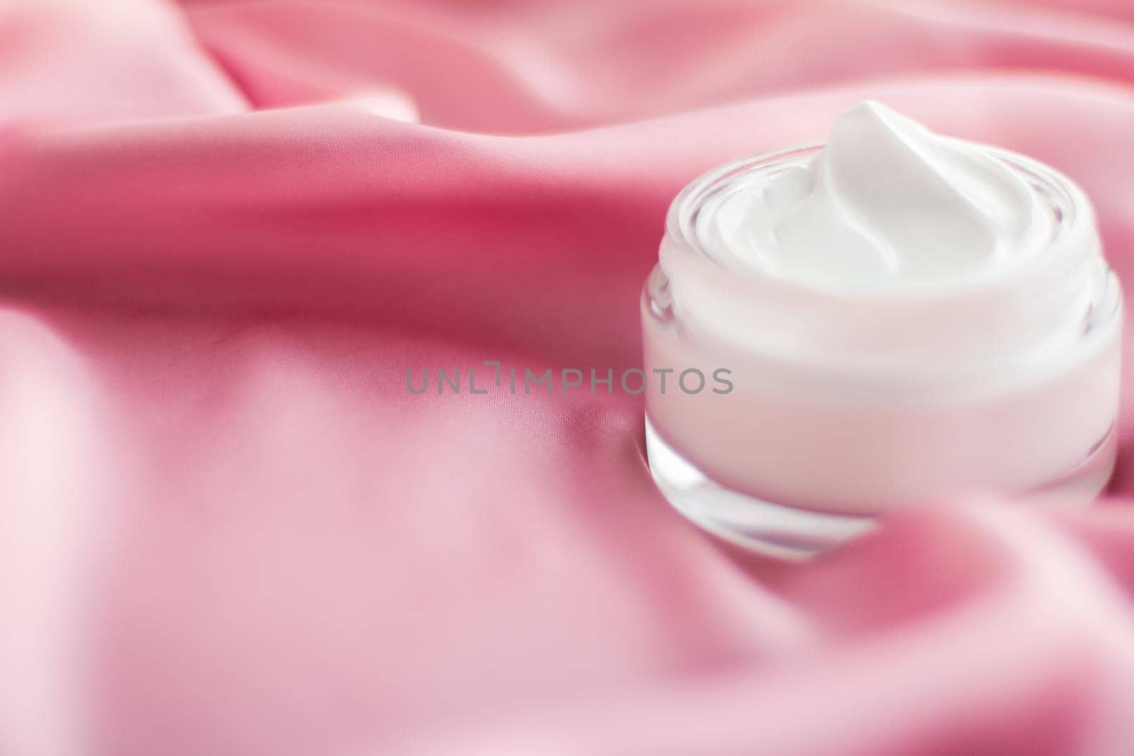 Beauty, anti-age cosmetics and skincare concept - Luxury face cream jar on a soft pink silk